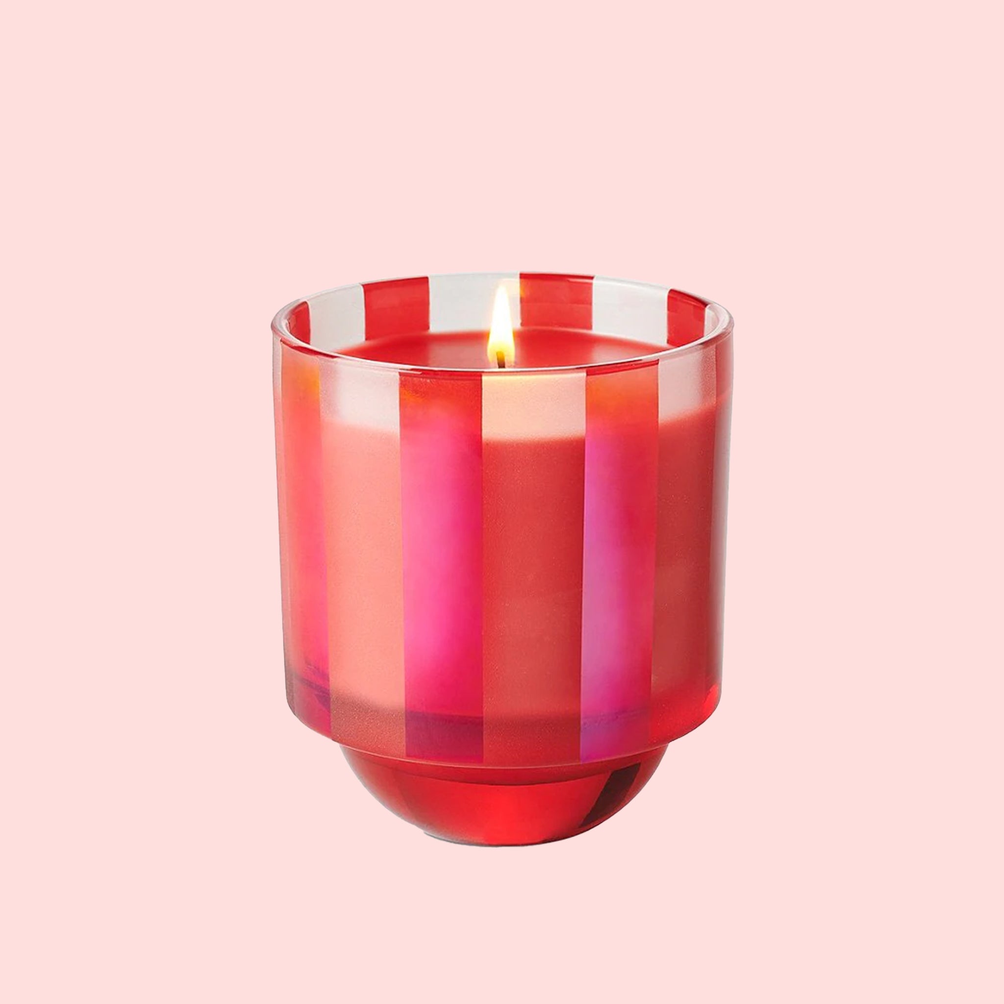 A striped pink and red glass candle in a pink and red box. 