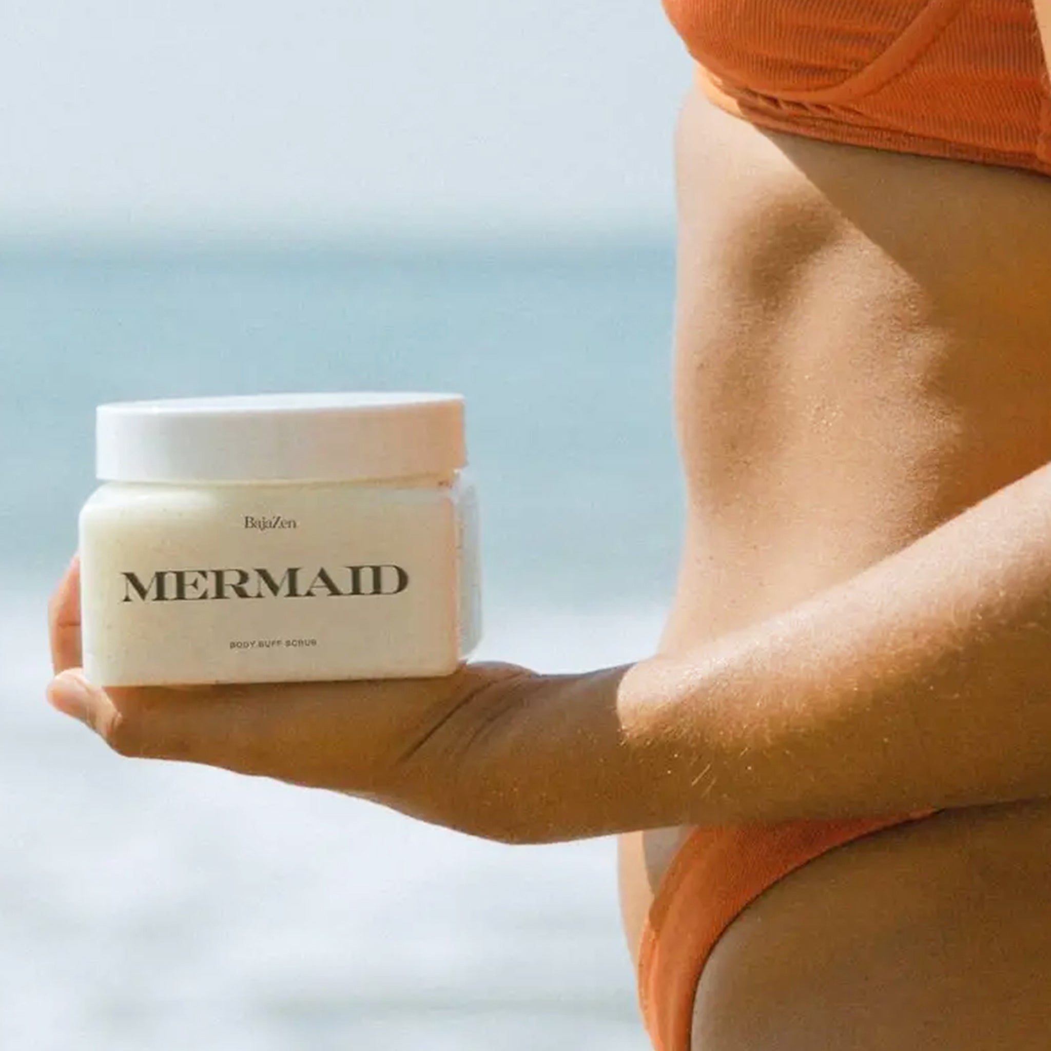 A clear container with white scrub, white lid and black text that reads, "Mermaid". 