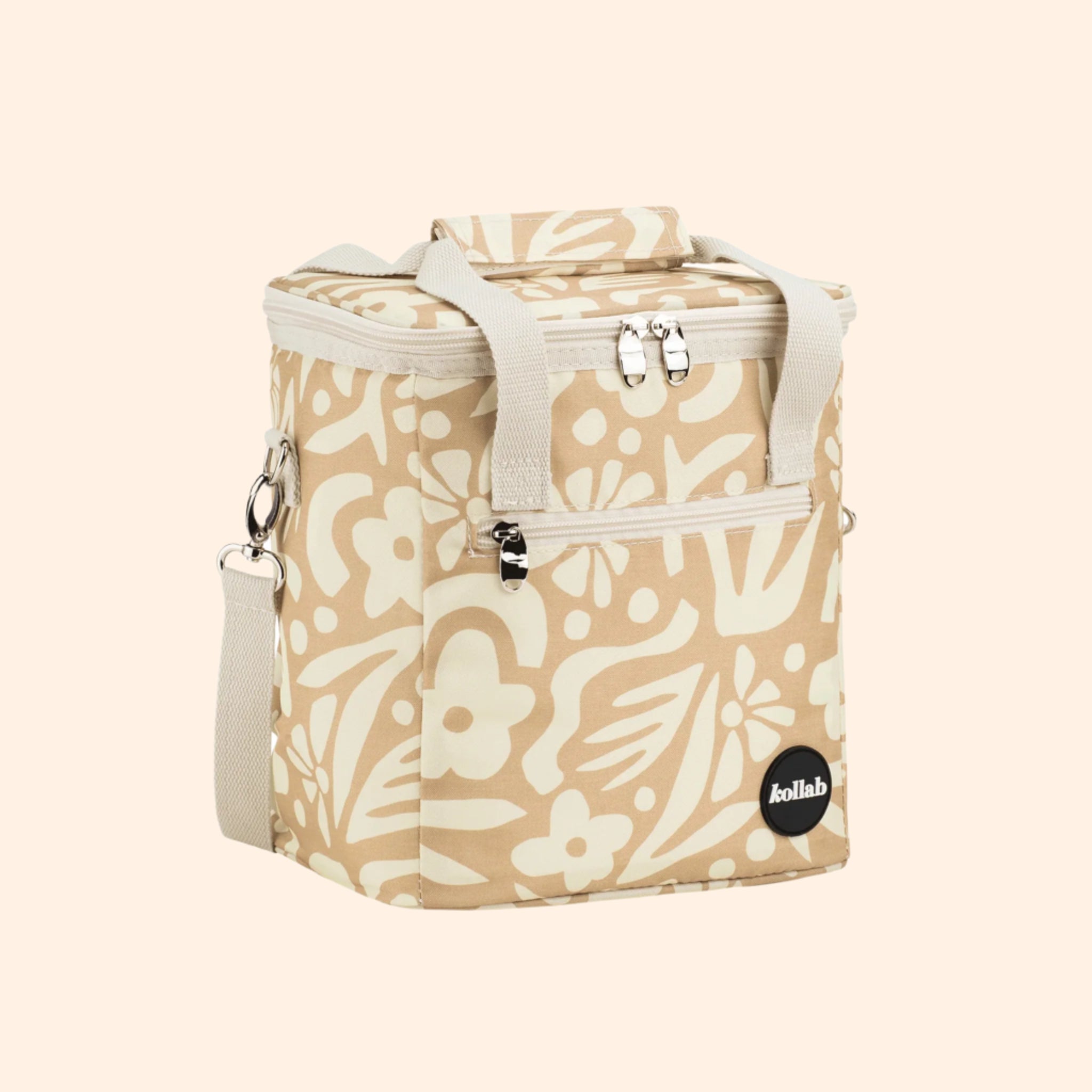 A white and tan floral mini cooler lunch box with a canvas strap 