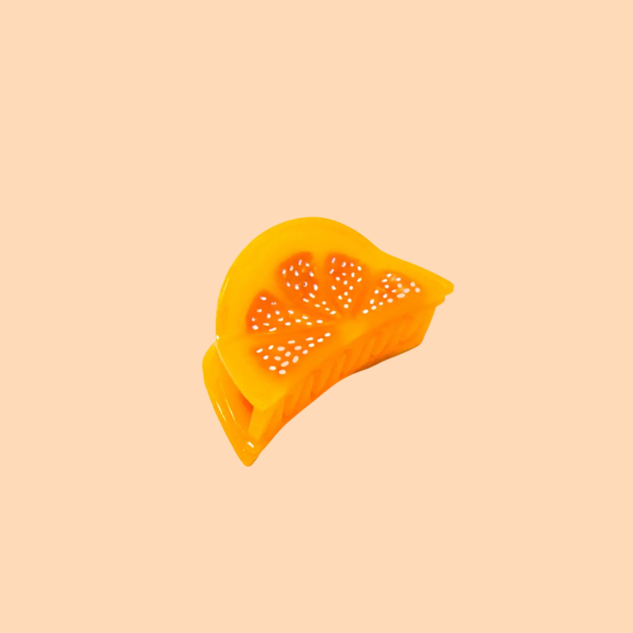 A mini orange slice shaped hair claw clip. 