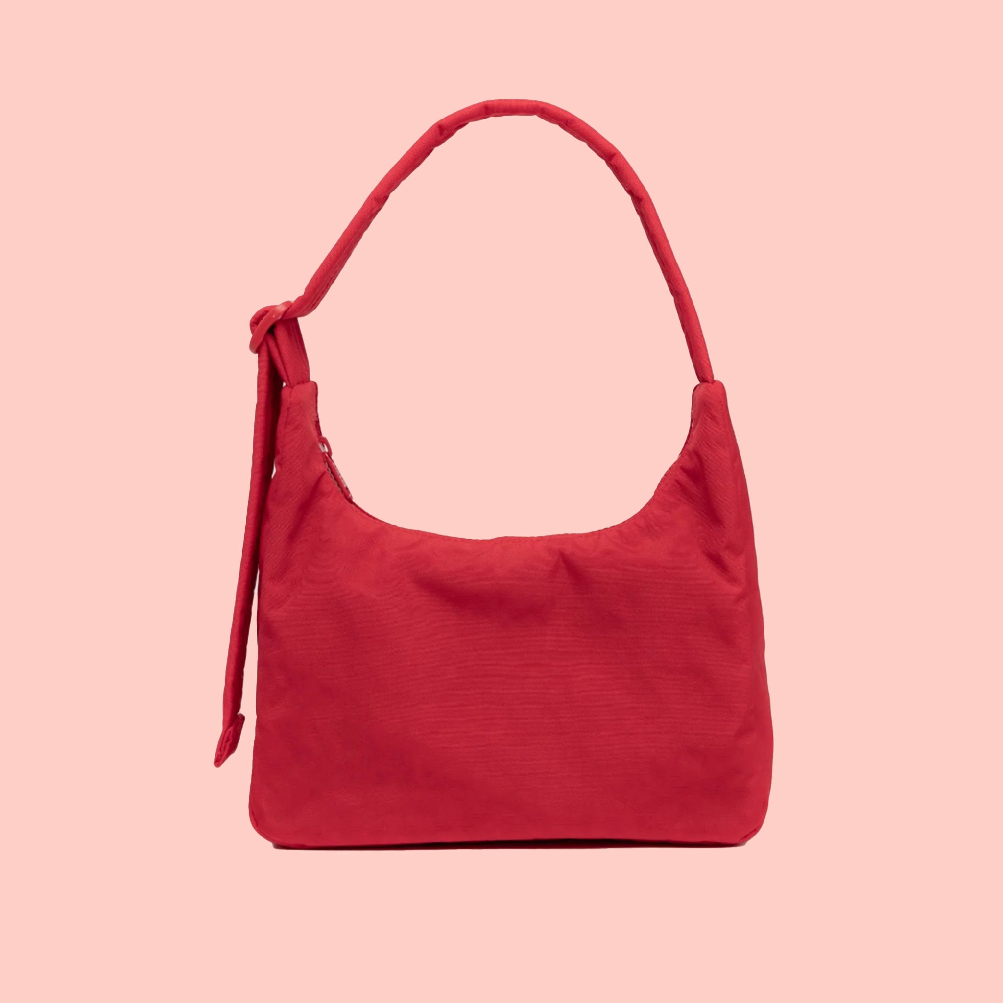 A red nylon shoulder bag with an adjustable strap. 