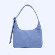 A blue squared off nylon shoulder bag with an adjustable strap.