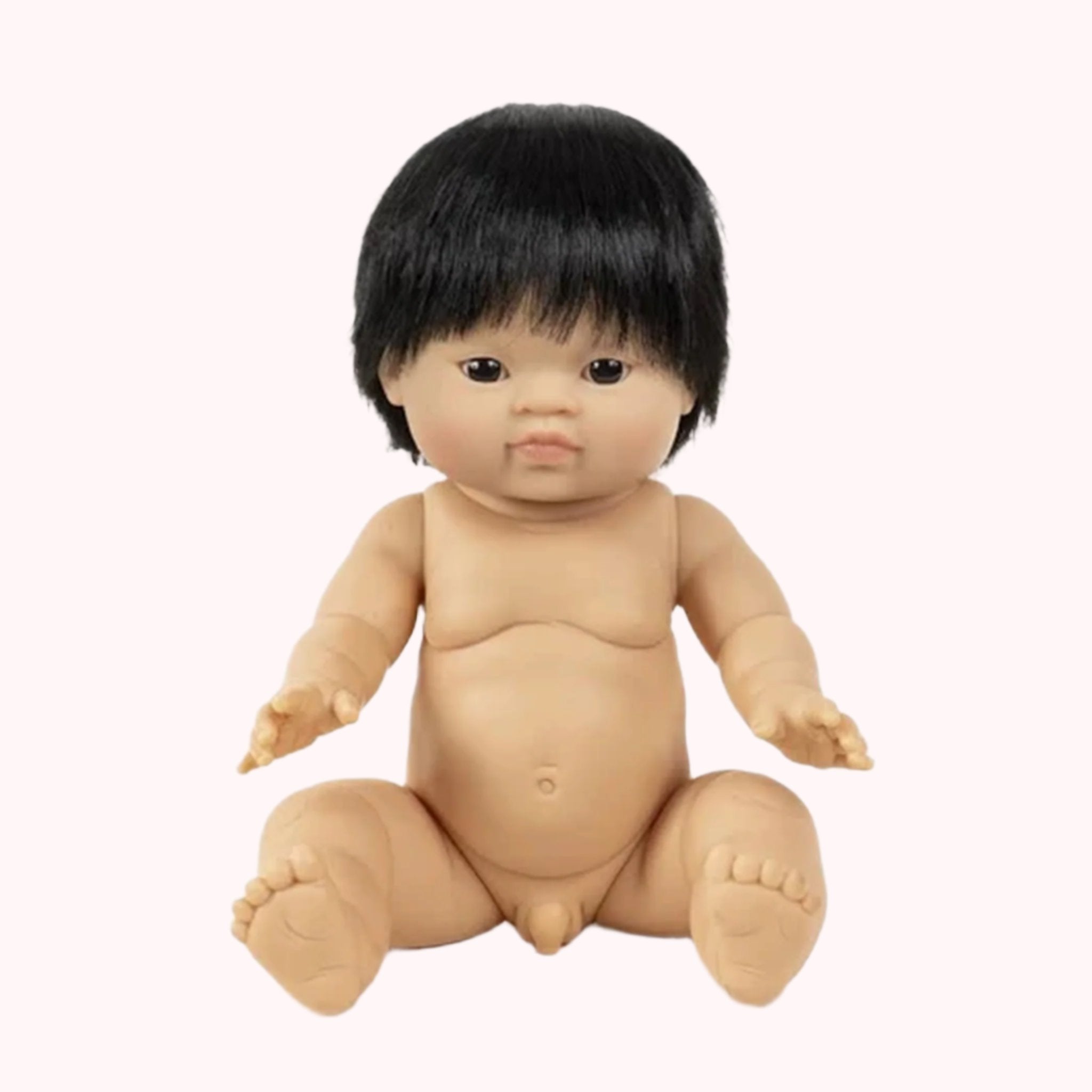 A baby boy doll with dark brown eyes and brownish black hair. 