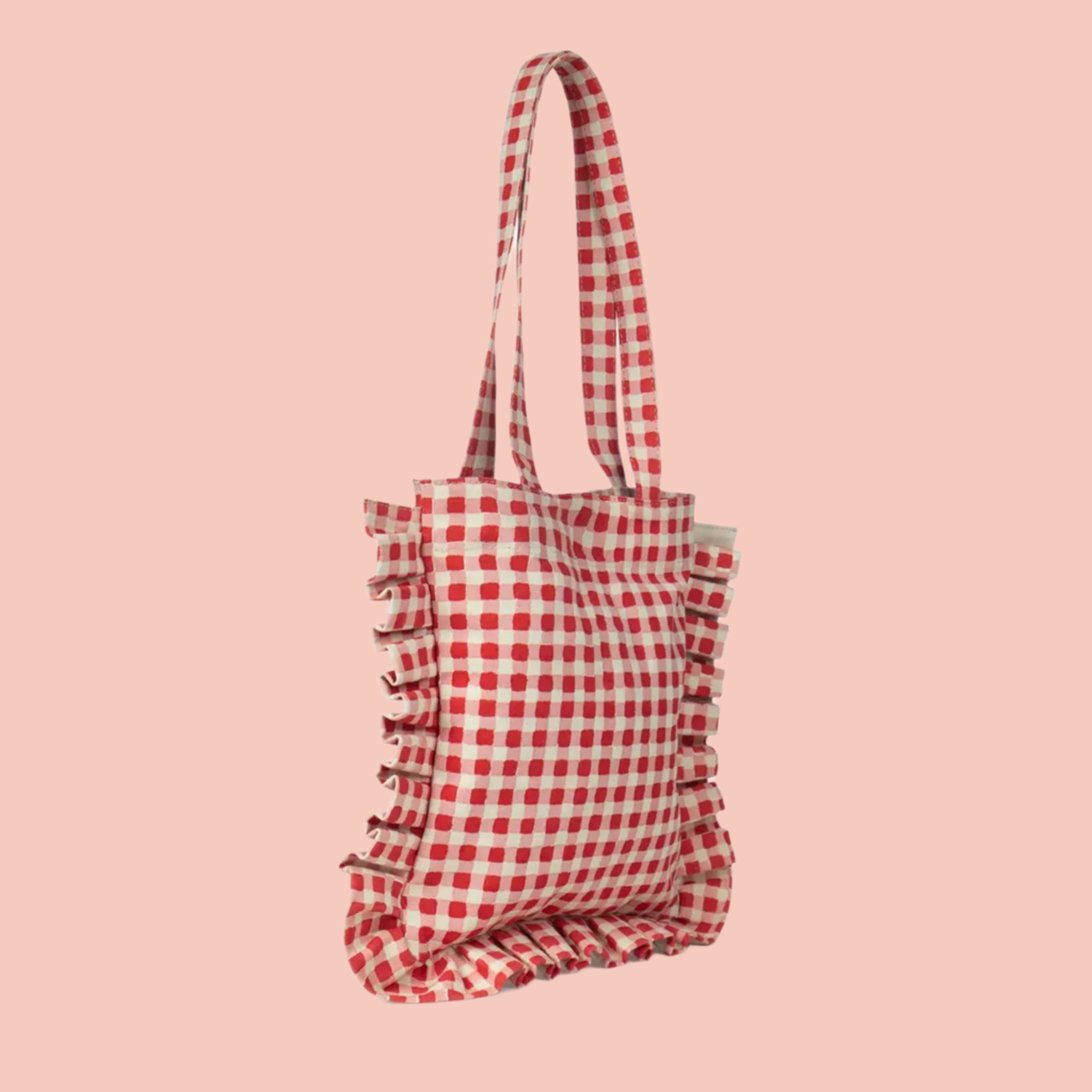 A red and white gingham printed tote bag with shoulder straps and a ruffle edge detail. 