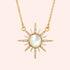 A gold starburst shaped necklace with small CZ stones in the rays and a Mother of Pearl stone in the center. 