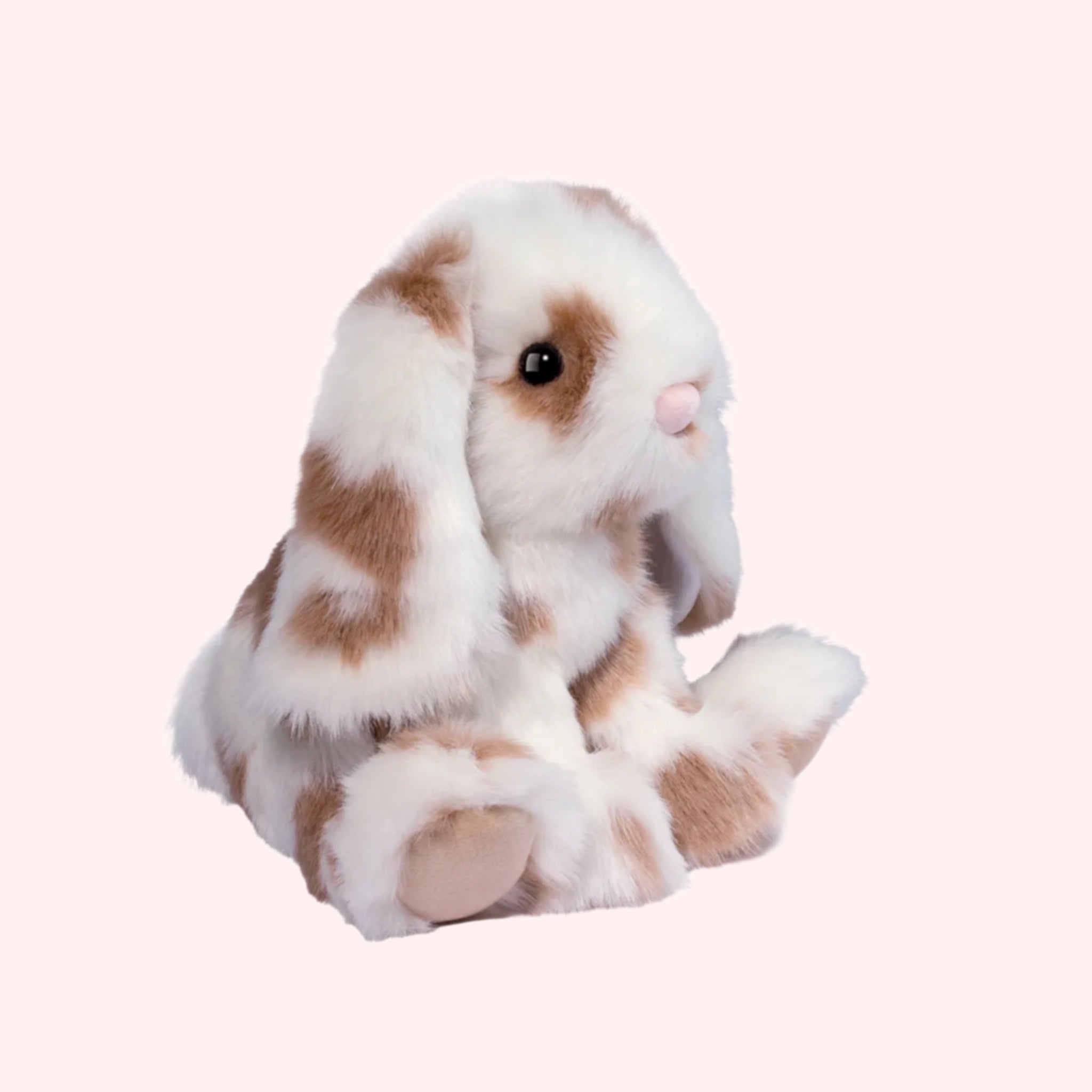 A brown and white spotted bunny shaped stuffed animal. 