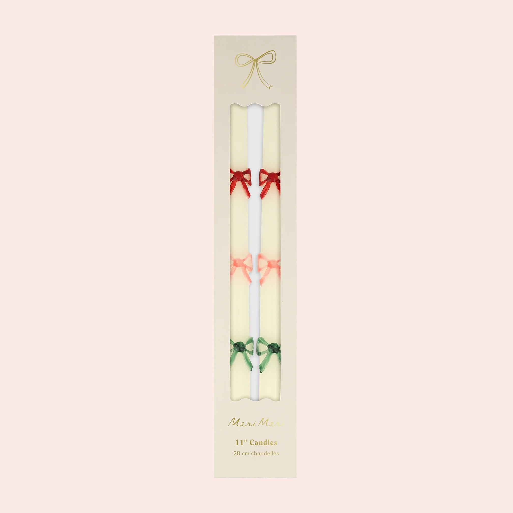 A set of two white taper candles with red, pink and green bow designs. 