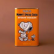 An orange rectangle tin of hot chocolate mix with a graphic of the Snoopy character wrapped up like a mummy and text that reads, 'Peanuts Mummy's Special Cocoa Afterlife Chocolate'. 