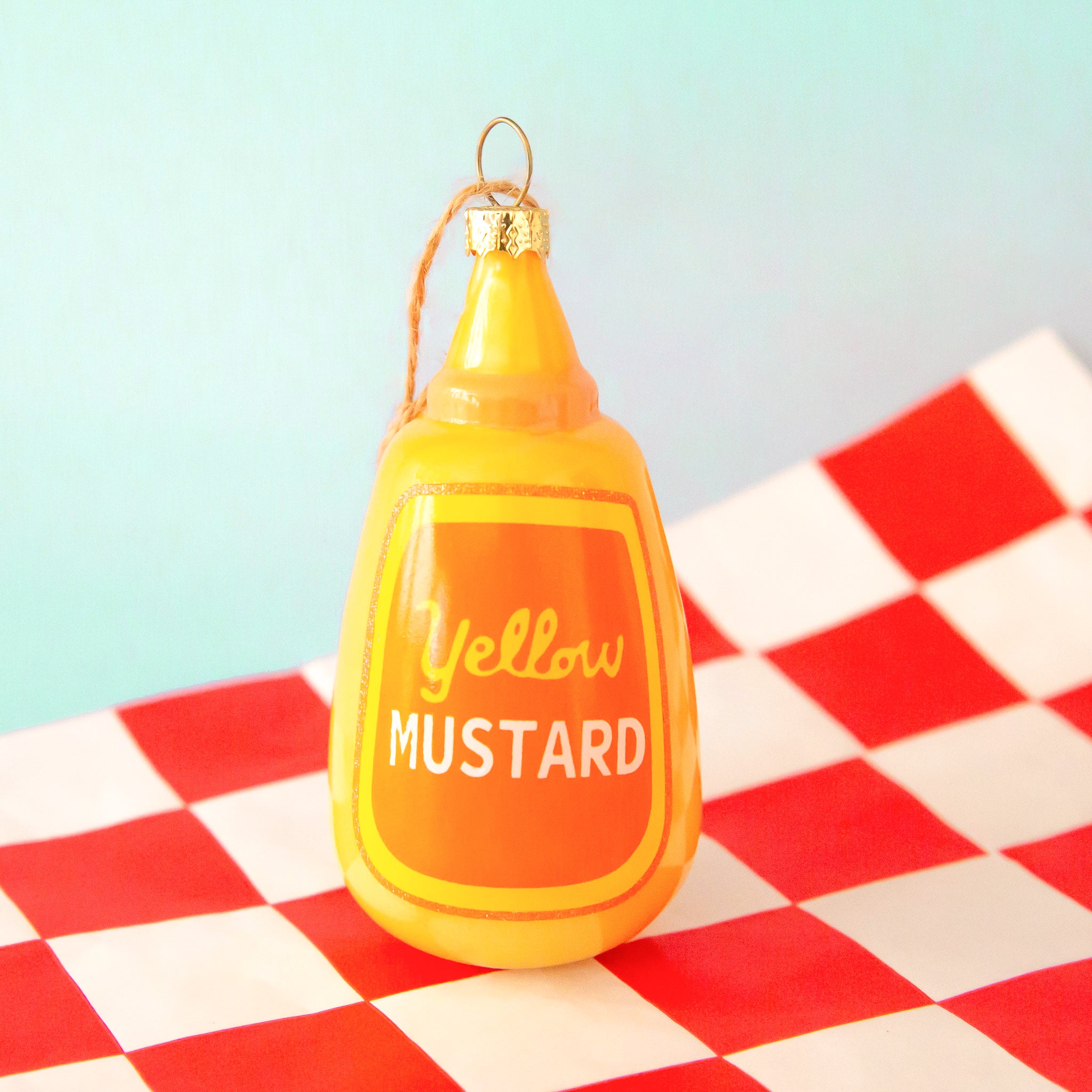 A yellow glass mustard bottle shaped ornament. 