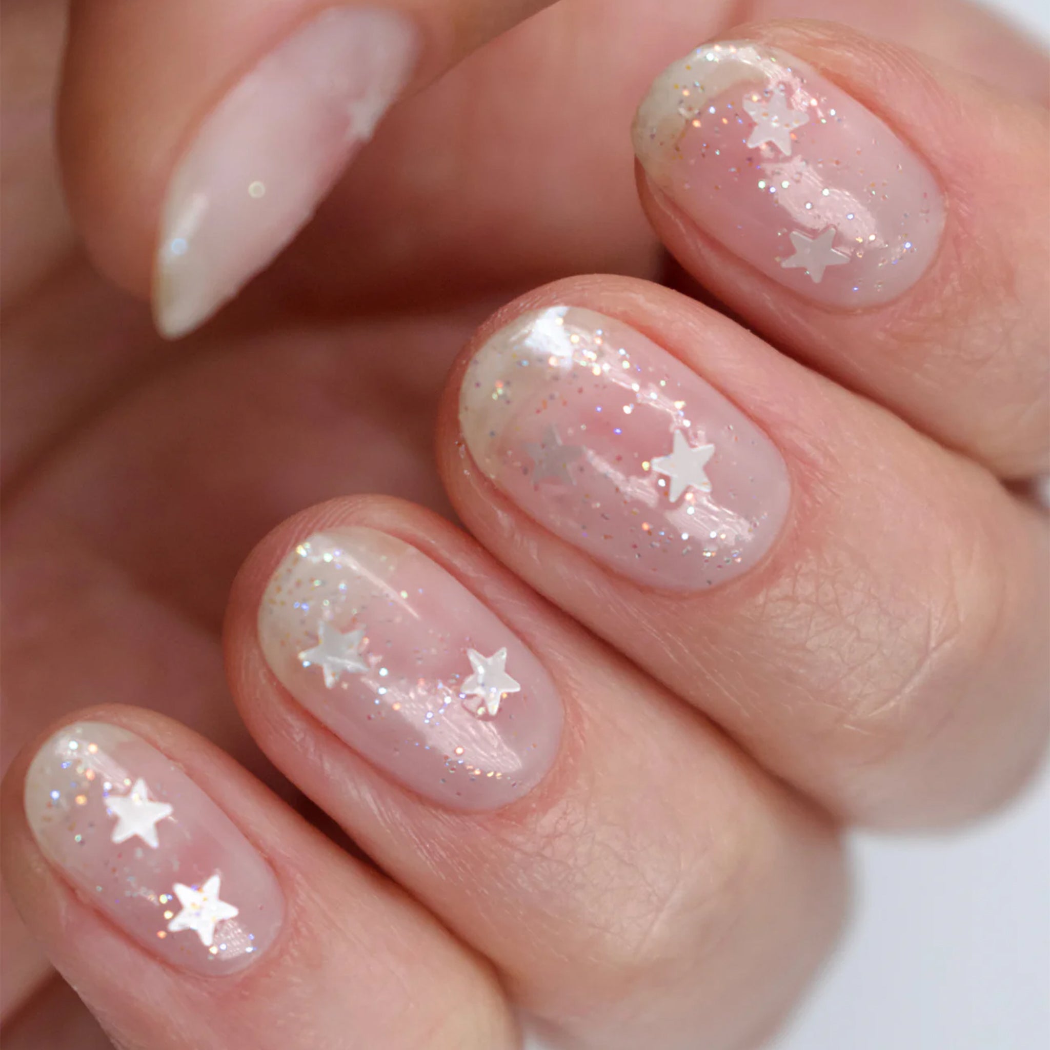 A sheer glitter nail polish with star glitter pieces.