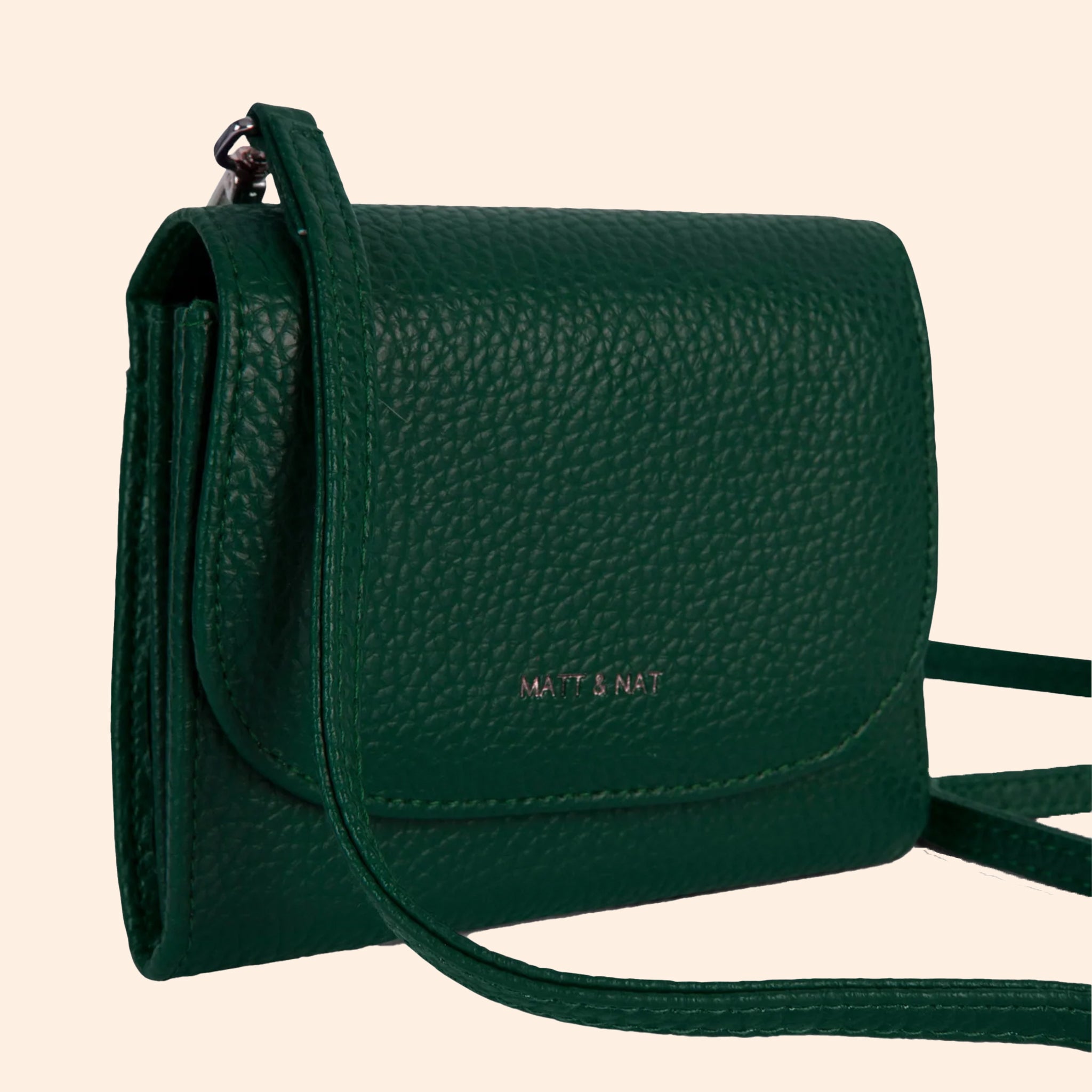 A dark green wallet with a removable crossbody strap. 