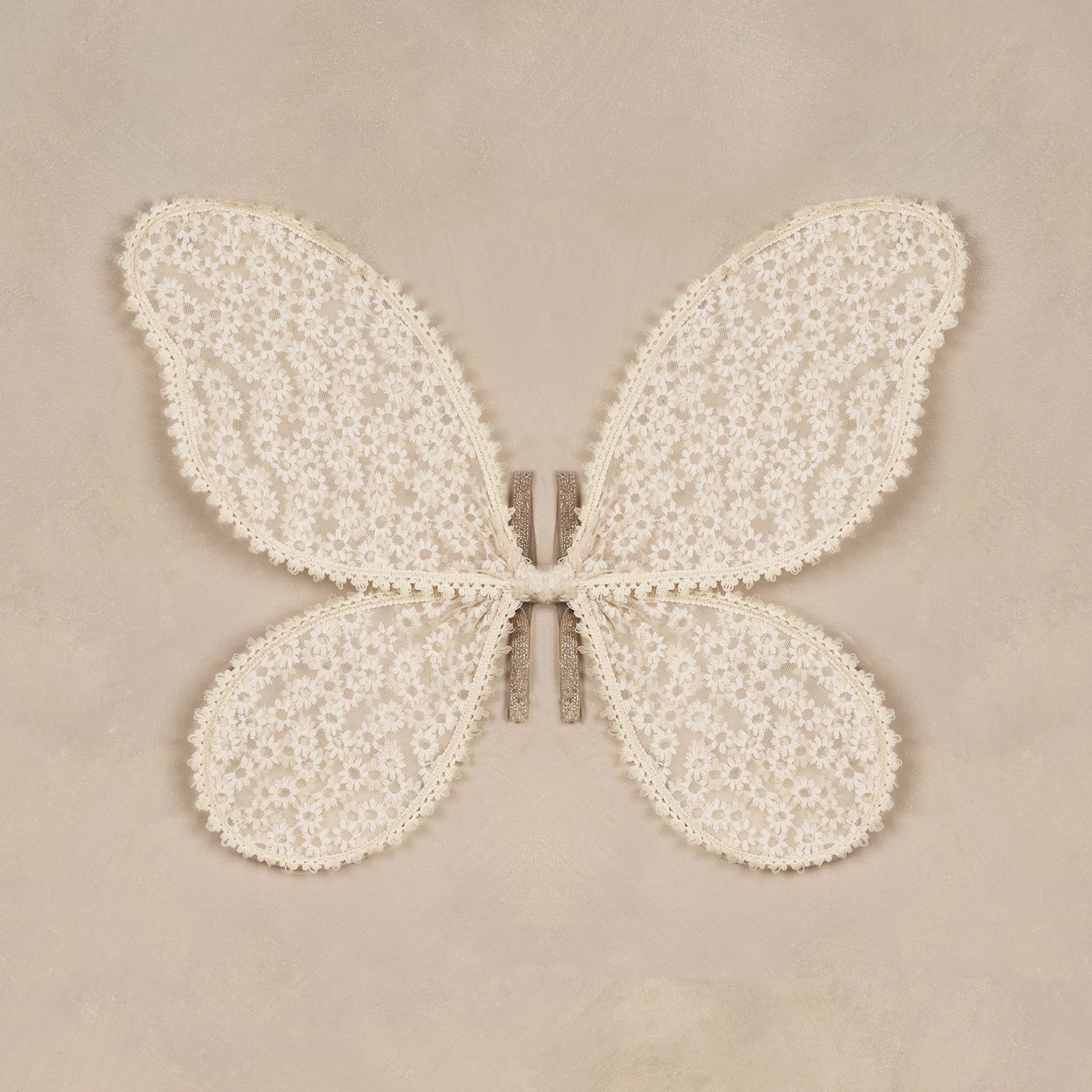 A natural colored pair of costume wings with an embroidered daisy pattern all over and elastic arm straps. 