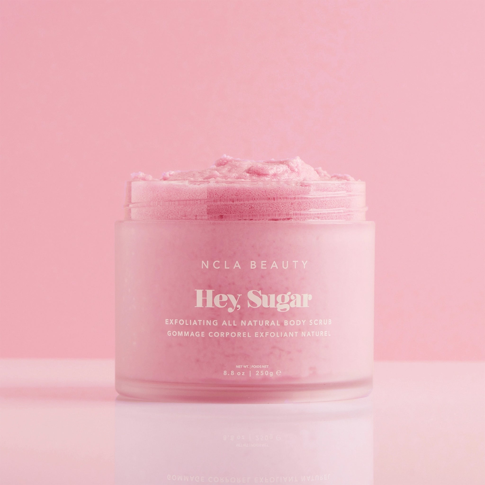 A pink container of sugar body scrub. 