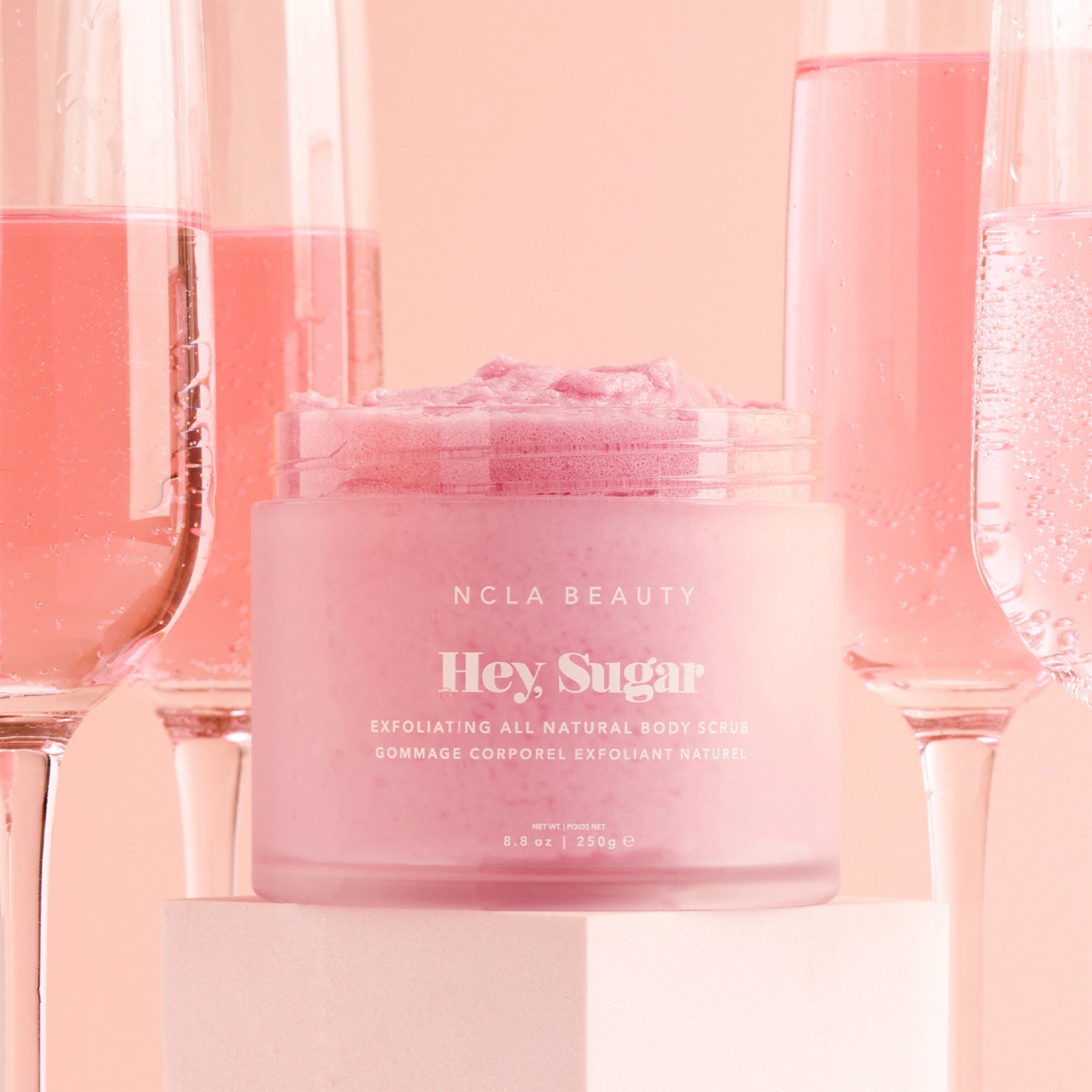 A pink container of sugar body scrub. 
