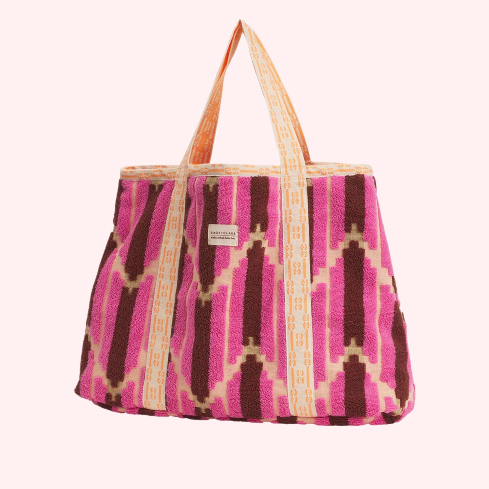 A terry tote bag with pink, burnt orange and yellow chevron design. 