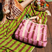 A terry tote bag with pink, burnt orange and yellow chevron design. 