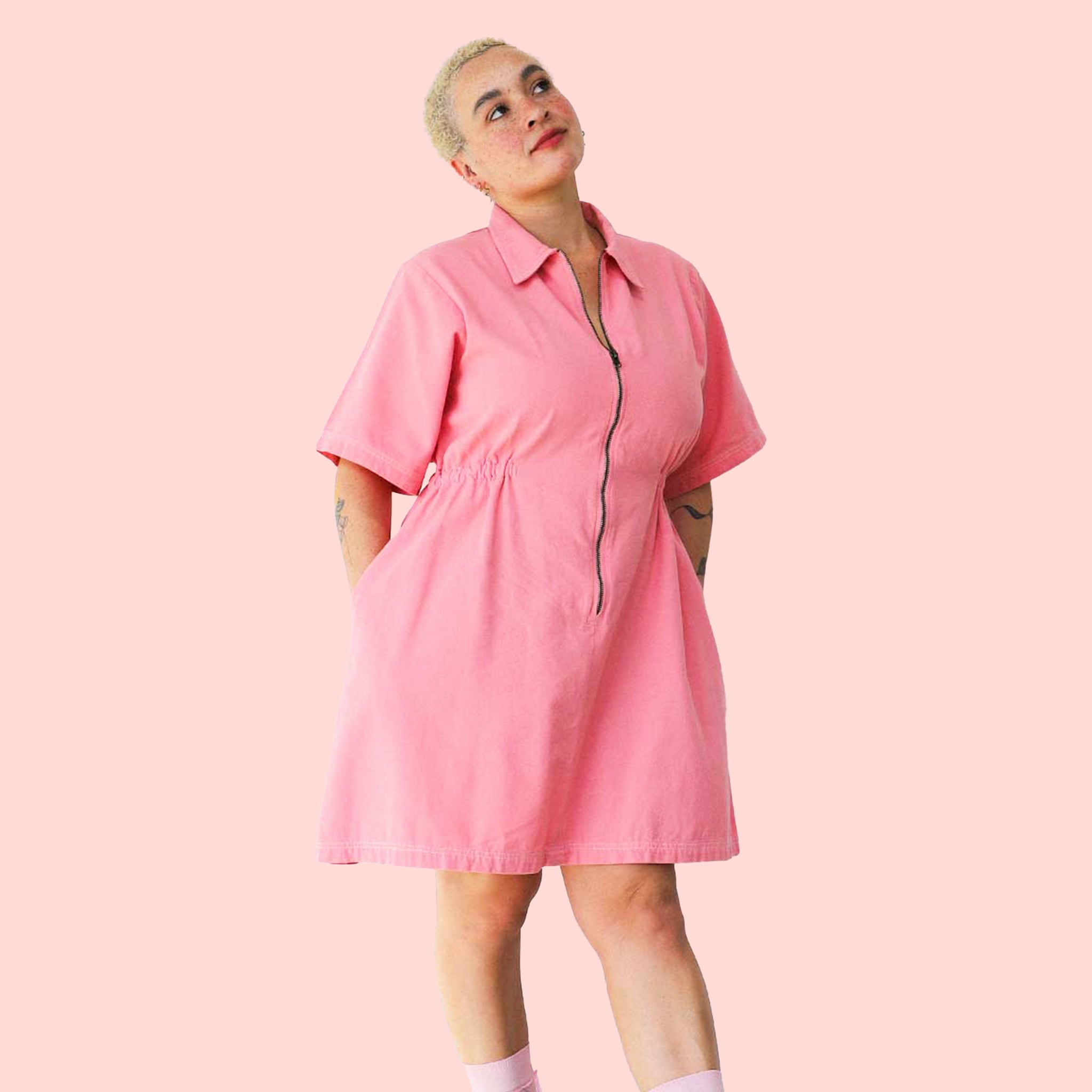 A short pink utility dress with a front zip and pockets. 