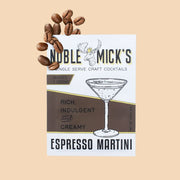 On a burnt orange background is a white and brown cocktail mix packet for espresso martinis with a graphic of a martini glass and a moose at the top that reads, "Noble Mick"s Single Serve Craft Cocktails".