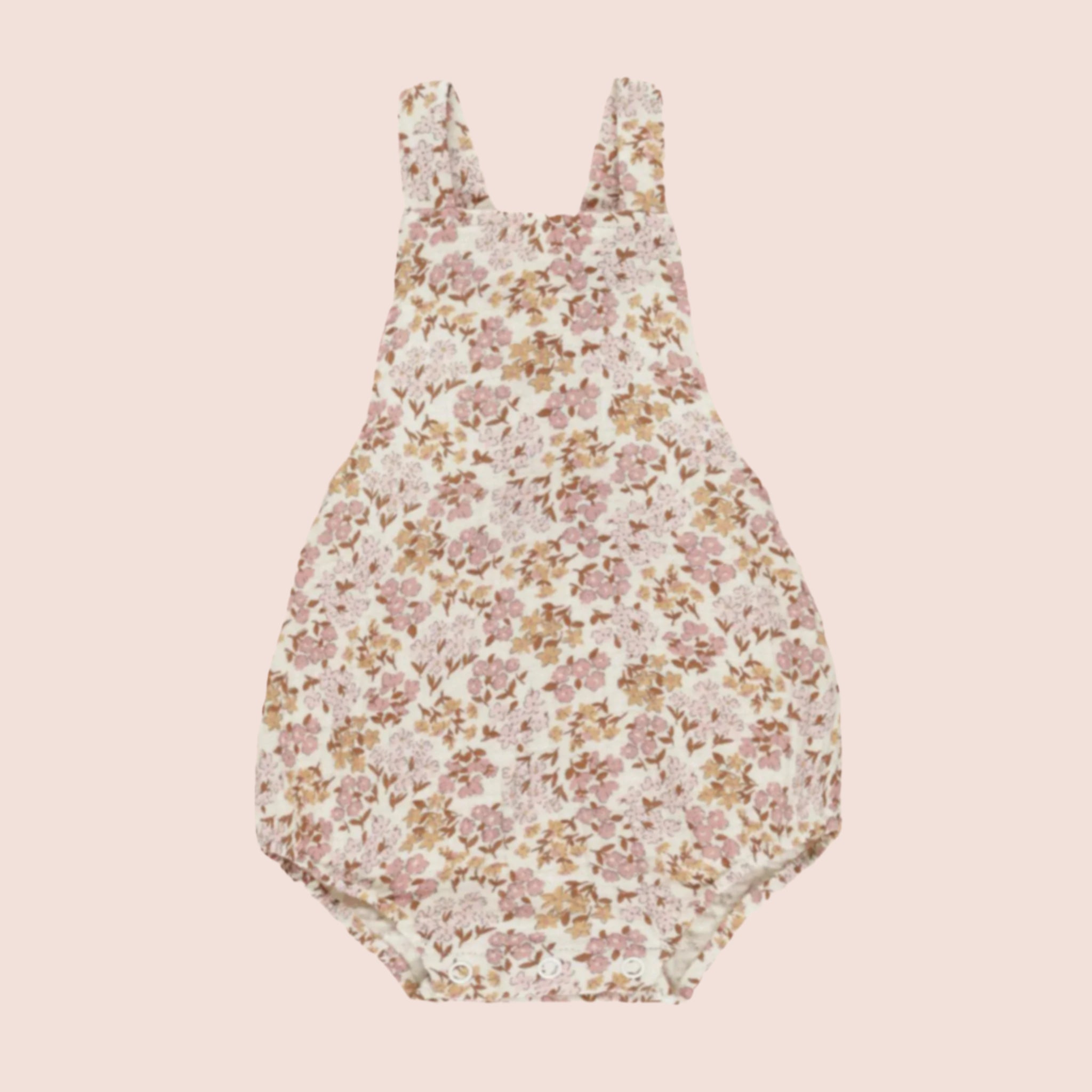 A children's romper with a light pink and yellow floral pattern. 