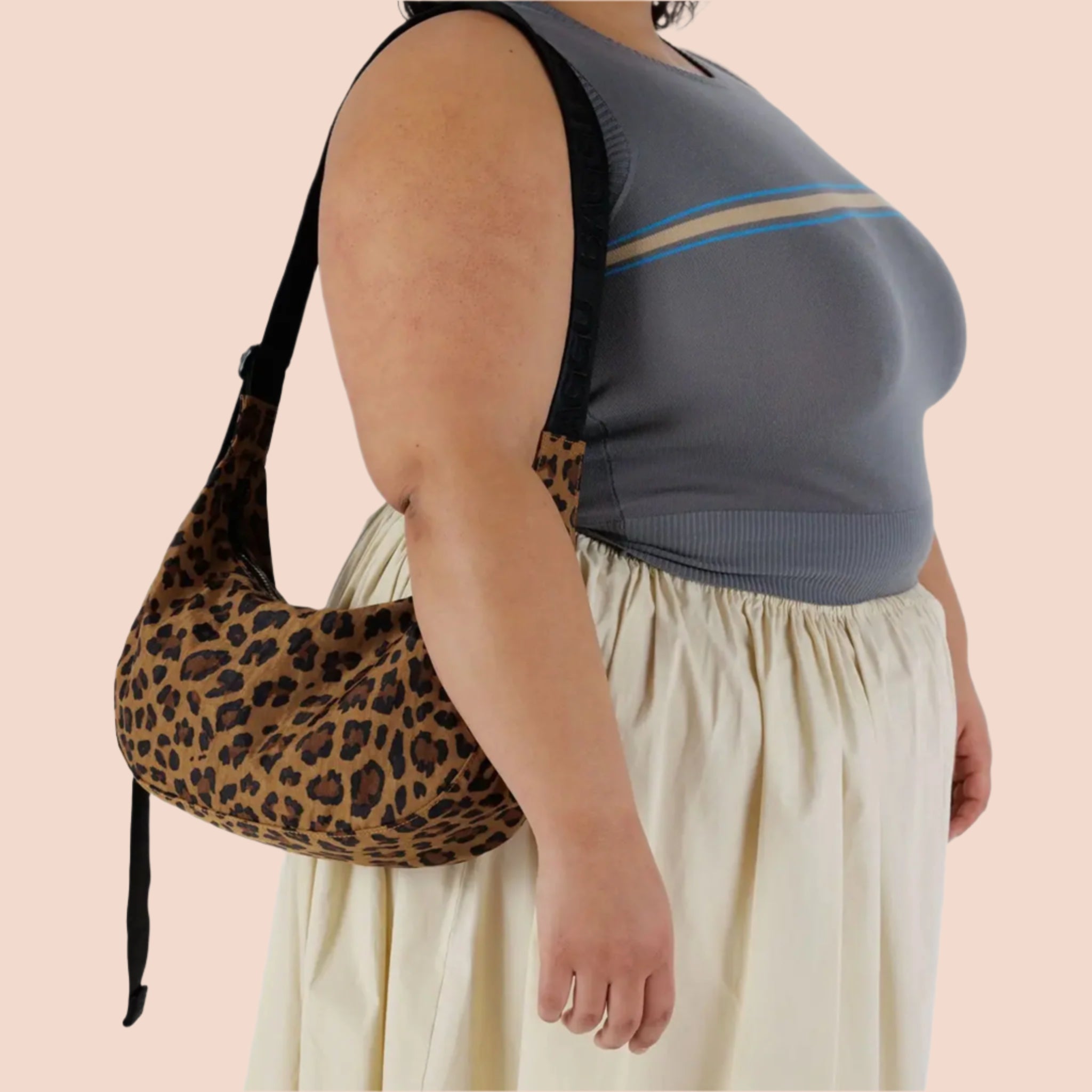 A medium sized crescent shaped bag with a leopard print and black adjustable strap. 