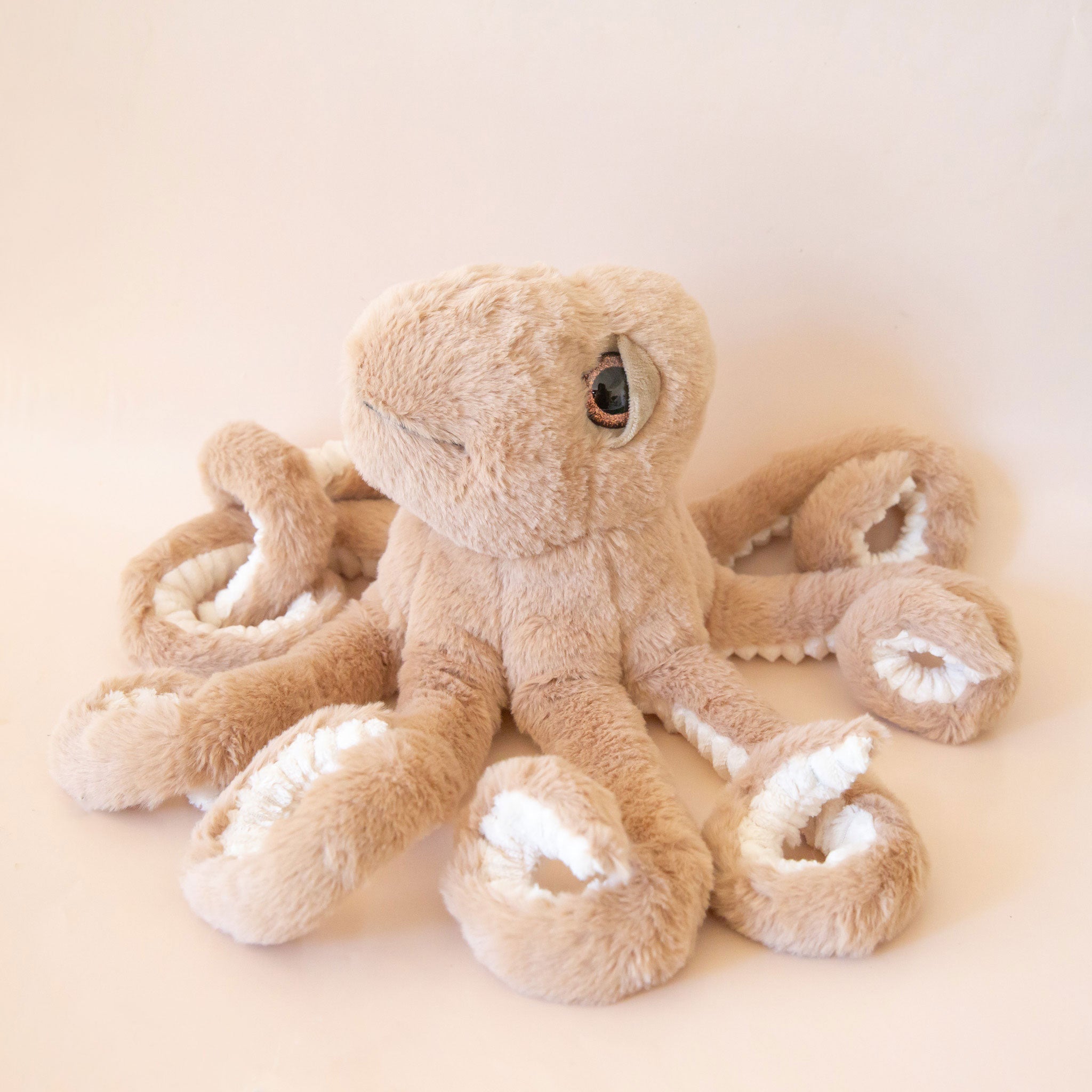 A brown octopus shaped stuffed animal. 