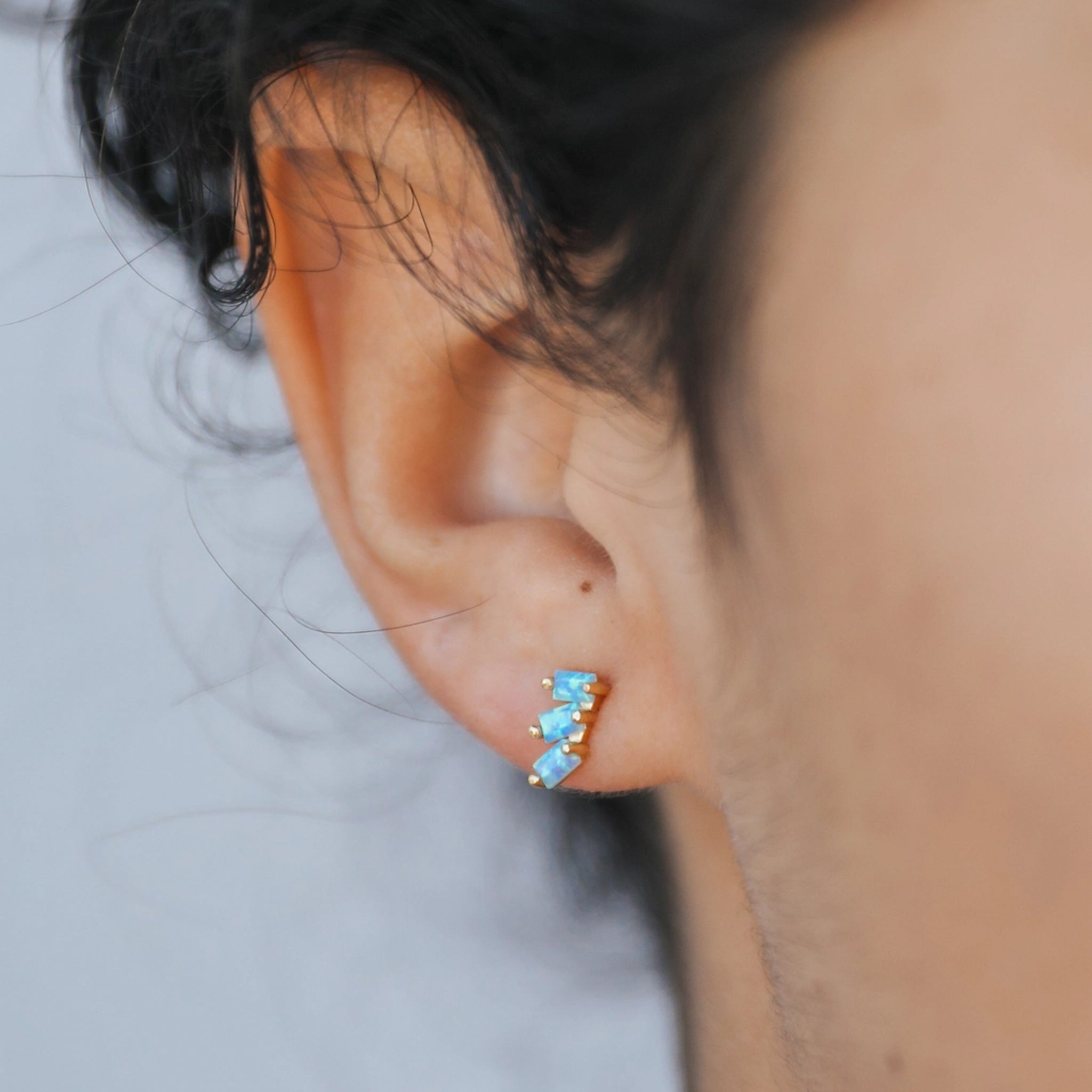 A pair of earrings with three offset fire opal stones. 