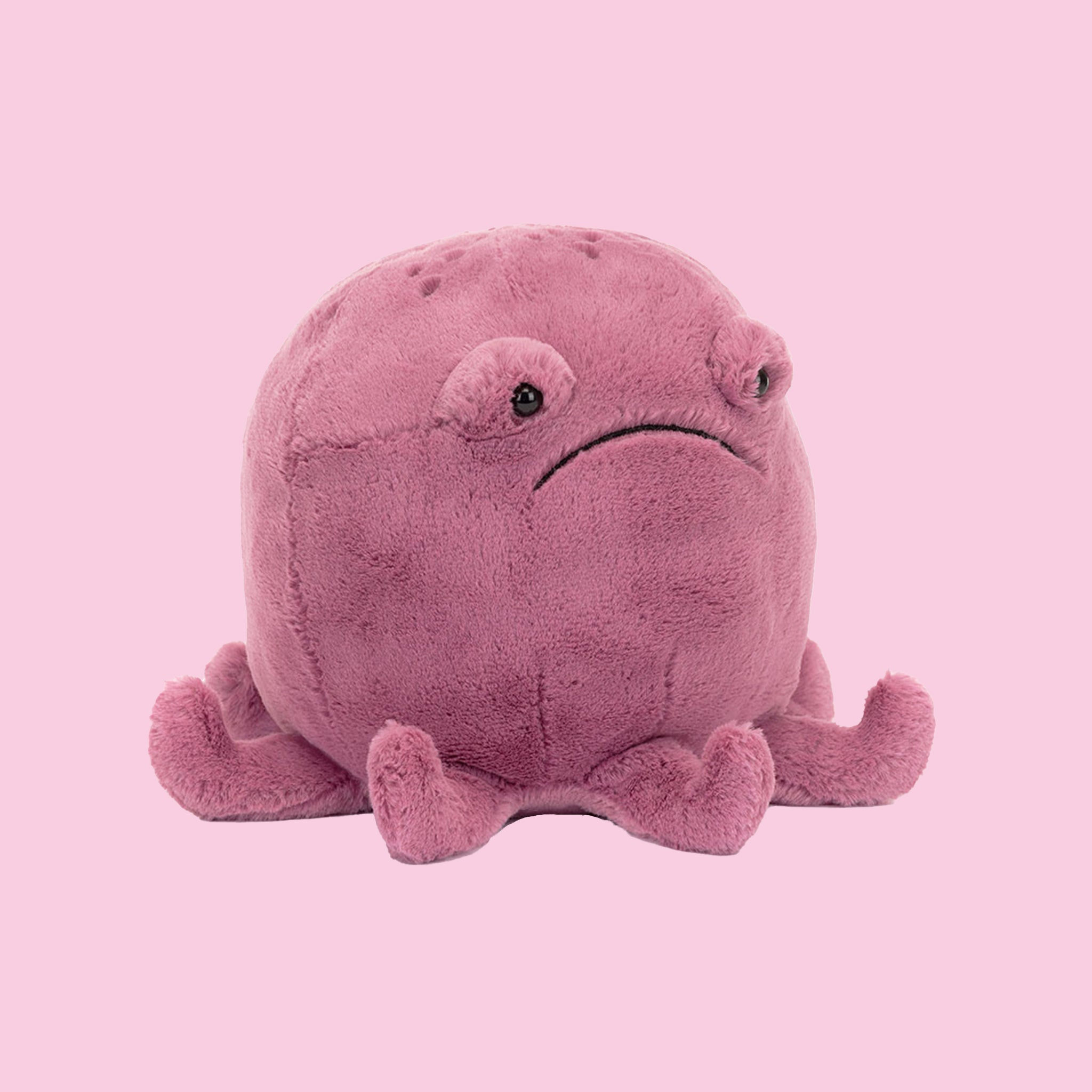 A magenta octopus shaped stuffed animal toy. 