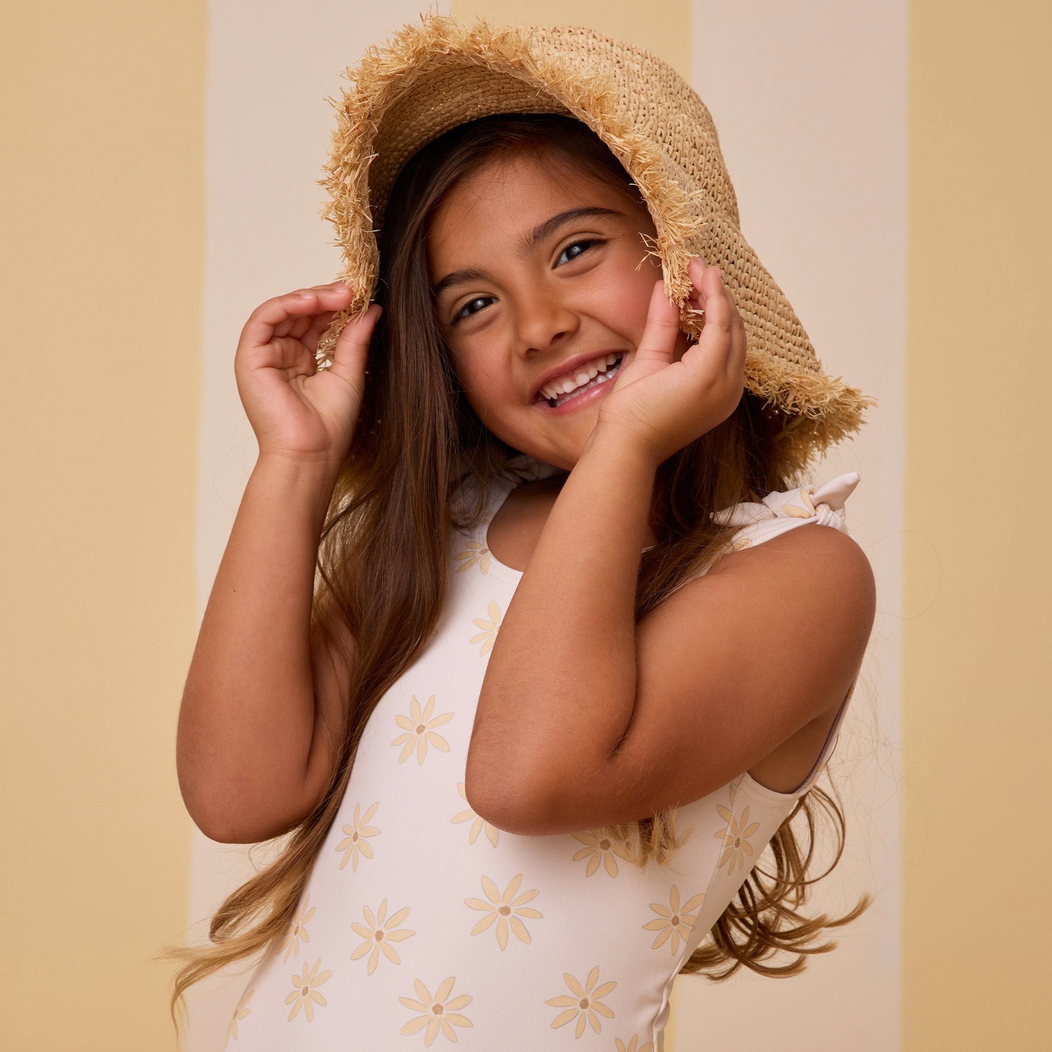 A cream one piece swim suit with a light yellow daisy pattern. 