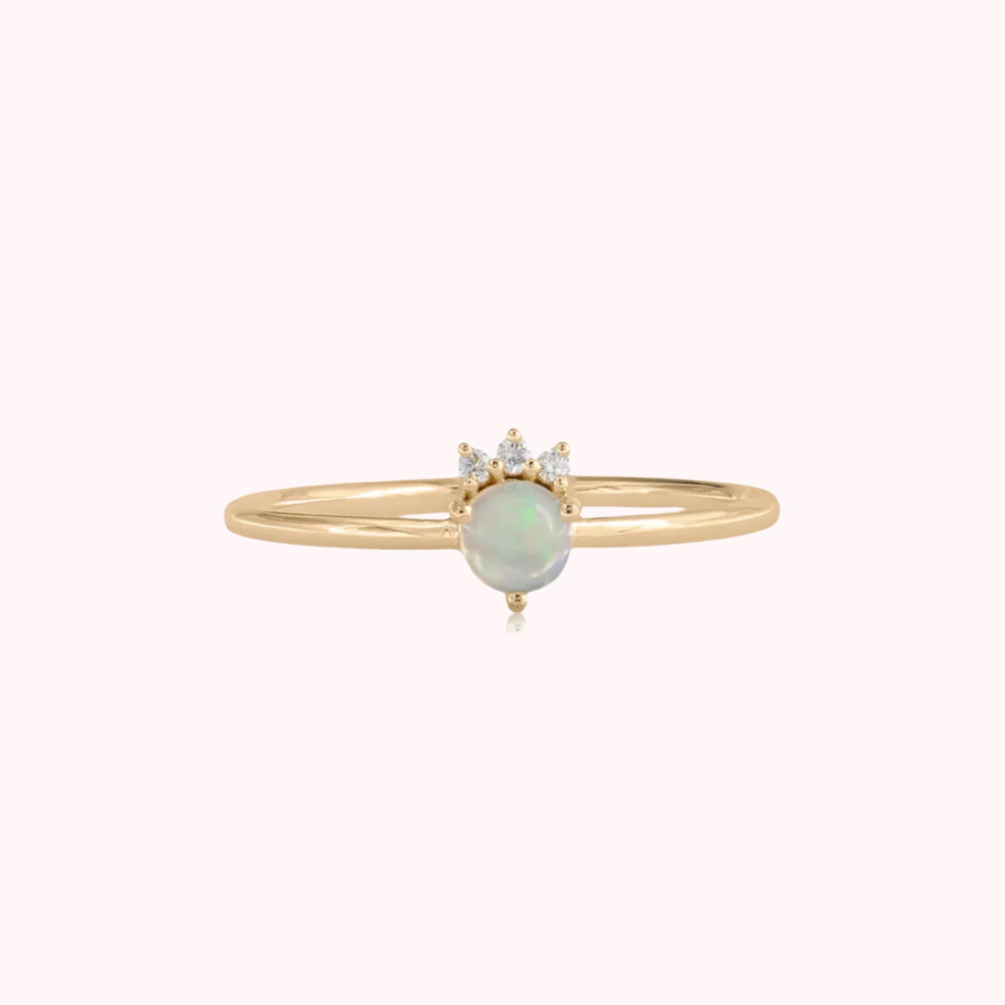 A gold ring with a blue opal stone in the center and three cz stones above. 