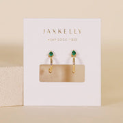 A pair of mini hoop earrings with a green CZ stone at the top of the hoop. 