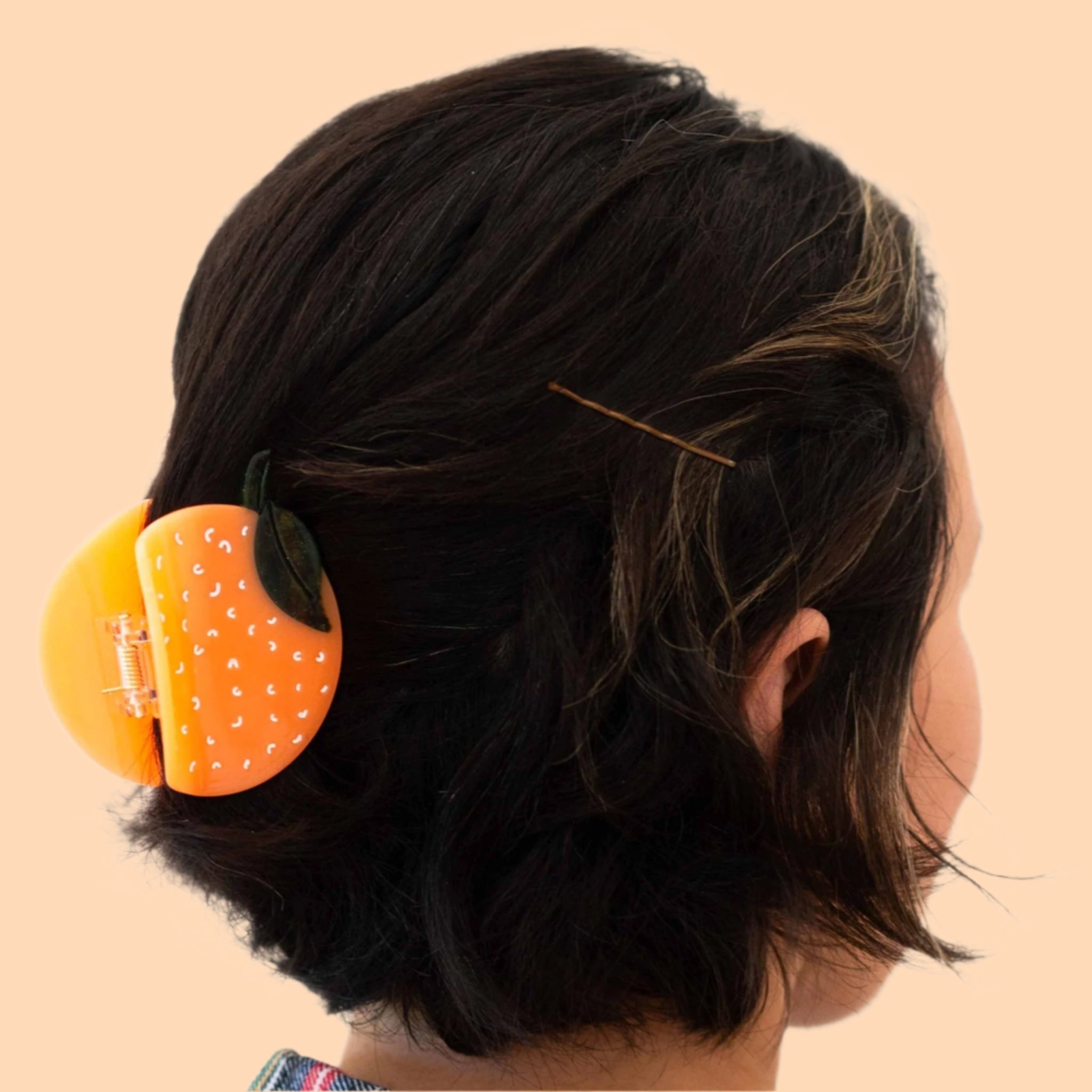 A circle orange shaped claw hair clip. 