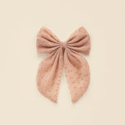 A pink oversized hair bow with an alligator clip on the back. 