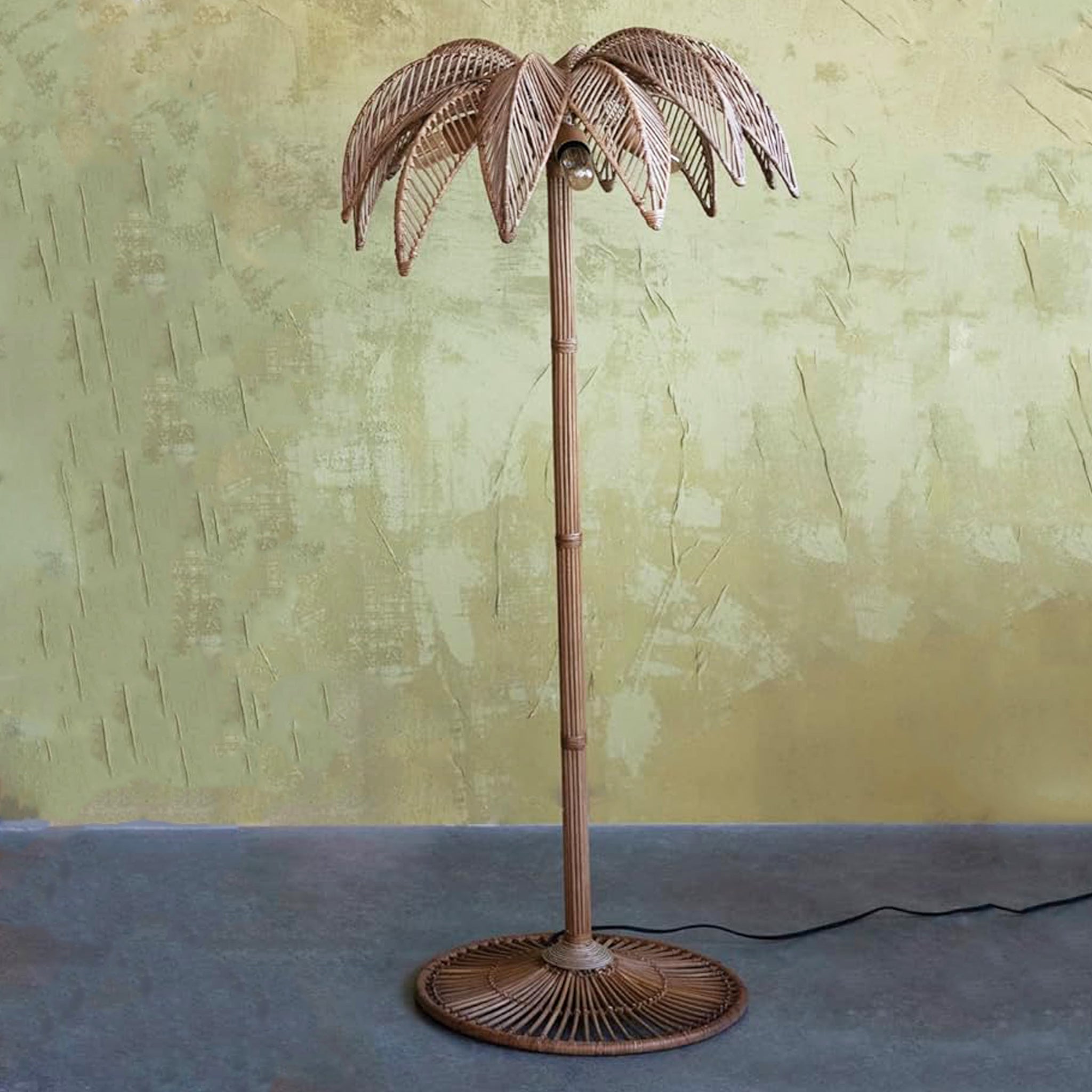 A brownish bronze metal palm tree shaped floor lamp. 