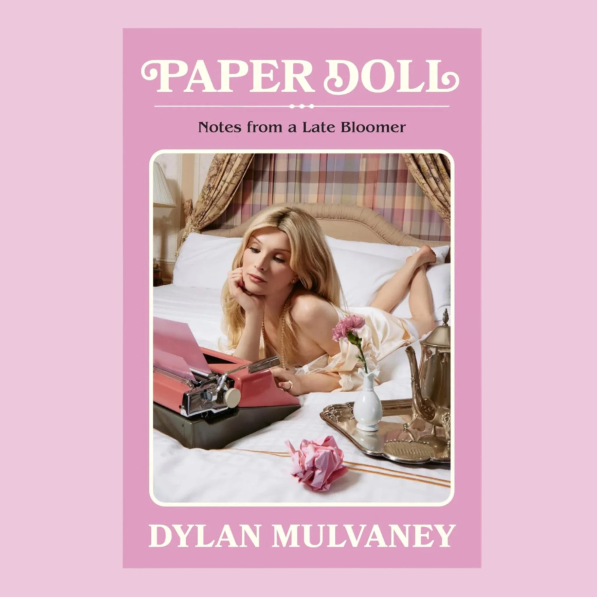 A pink book cover with a photo of Dylan Mulvaney and the title above that reads, 'Paper Doll Notes from a Late Bloomer'. 