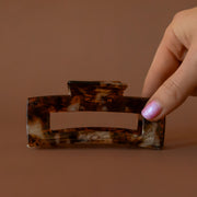 A brown feline inspired design on a plastic hair clip.