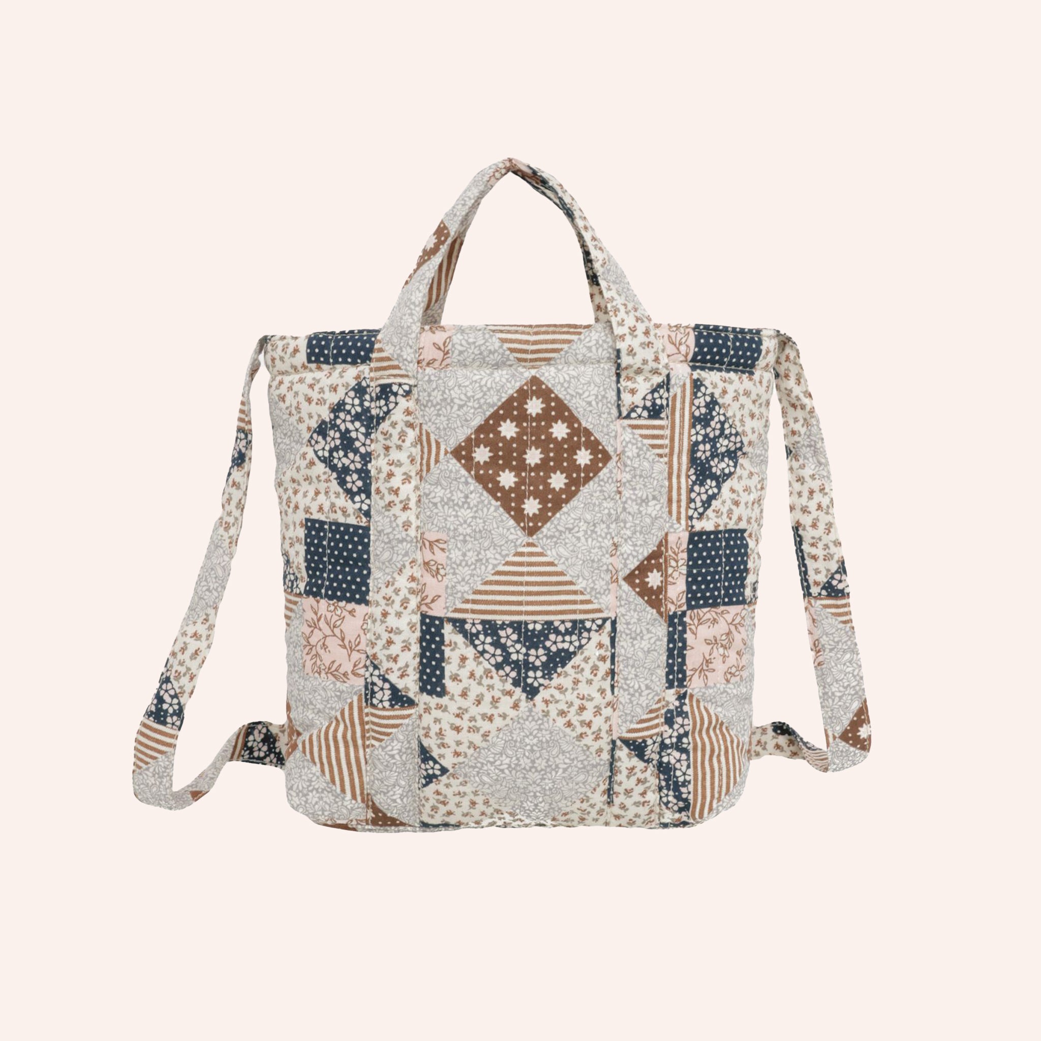 A blue and tan patchwork quilted bag with handles and a longer strap for over the shoulder. 