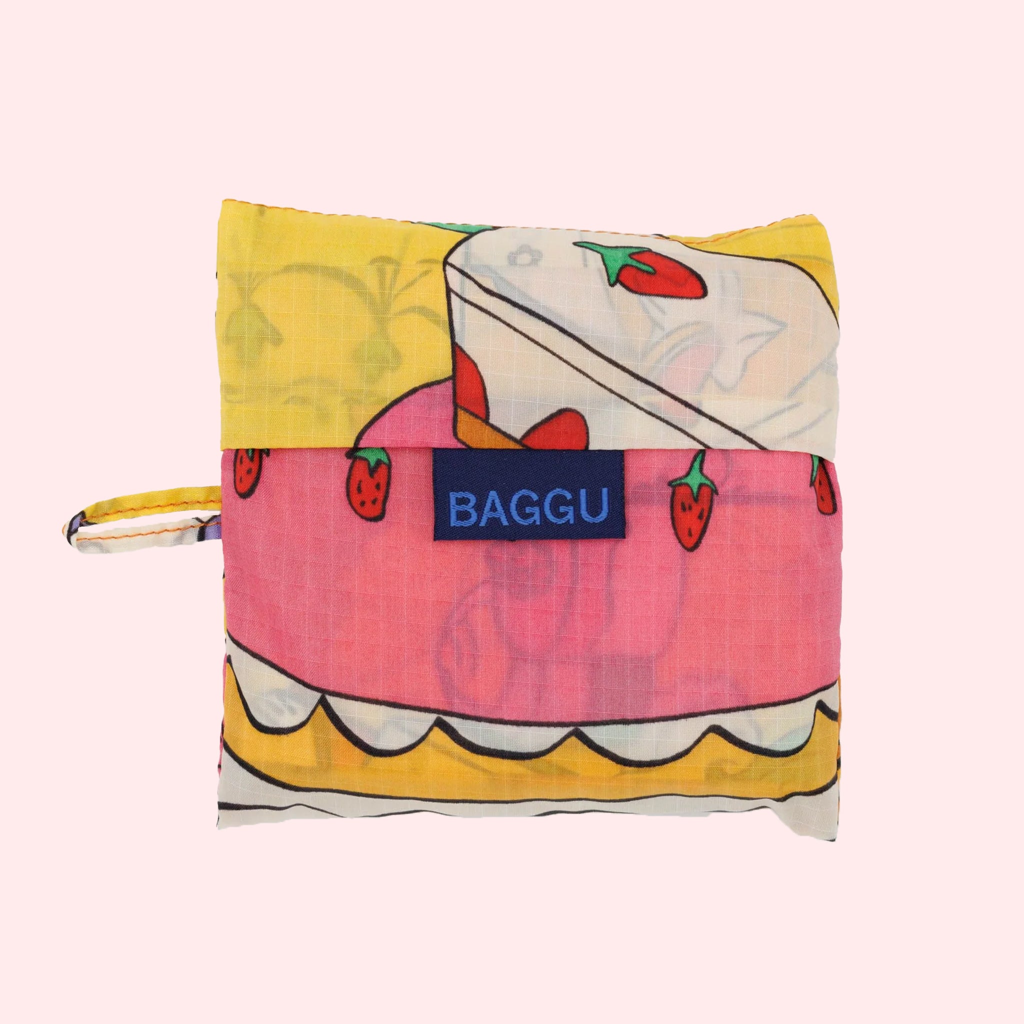 A yellow nylon tote bag with a colorful pattern of various desserts.'