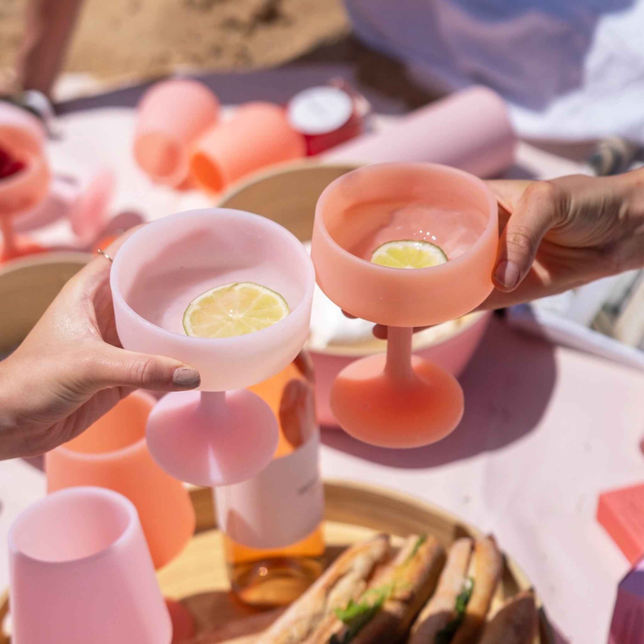 A pair of peachy and pink silicone coupe shaped cocktail glasses.