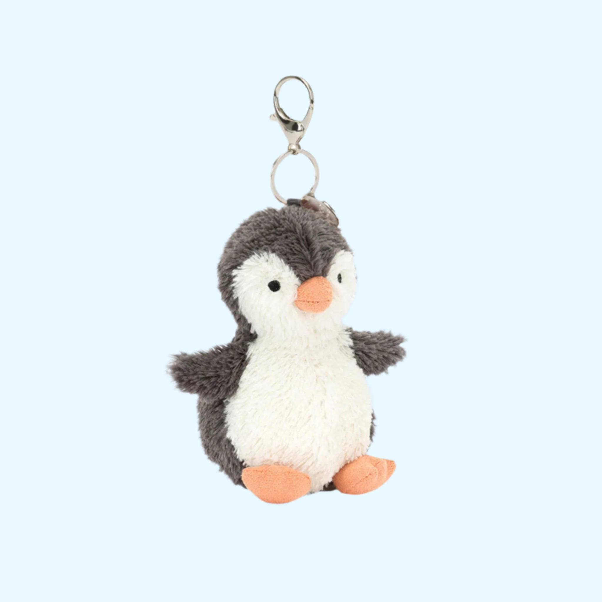 A penguin shaped bag charm with silver hardware. 