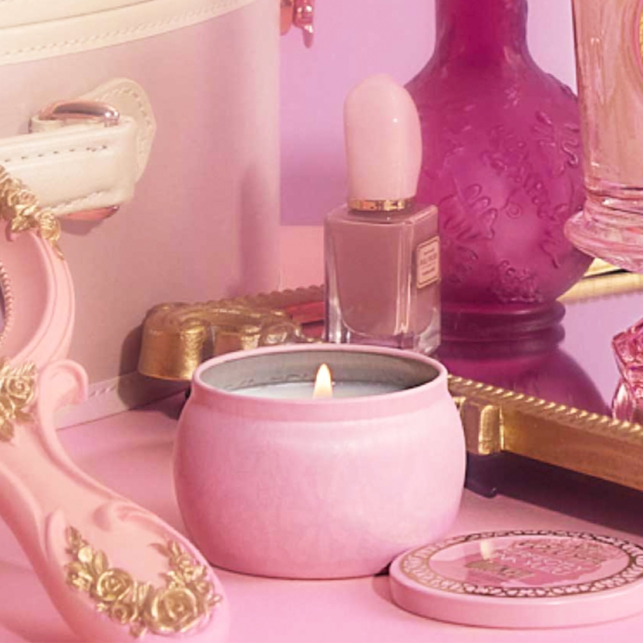 A small tin candle with a pink and gold detailed design that reads, &#39;Voluspa Perfectly Pink Yuzu Wicked&#39;. 