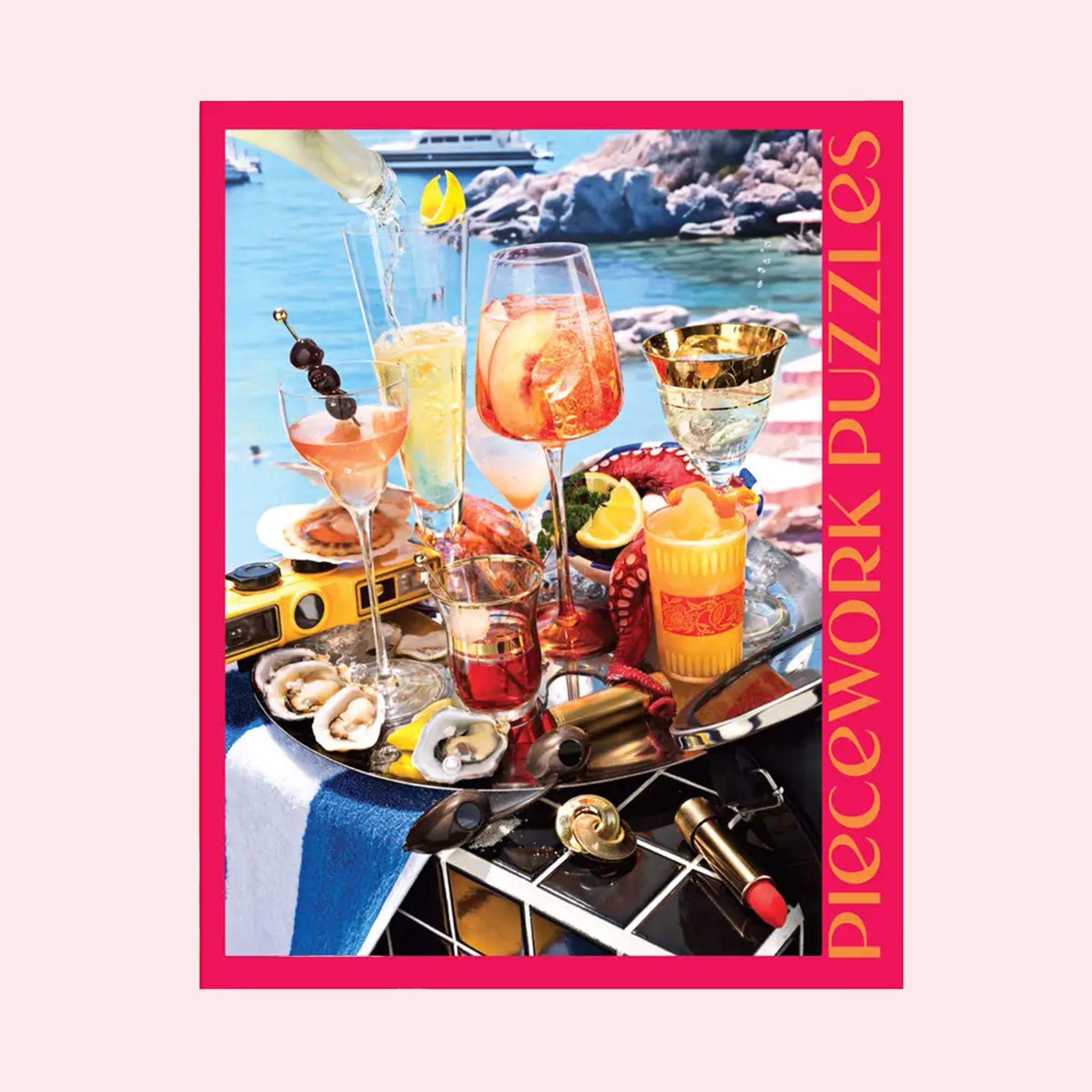 A hot pink puzzle box with an image of a beachside drinks tray with a variety of cocktails and beachside essentials. 