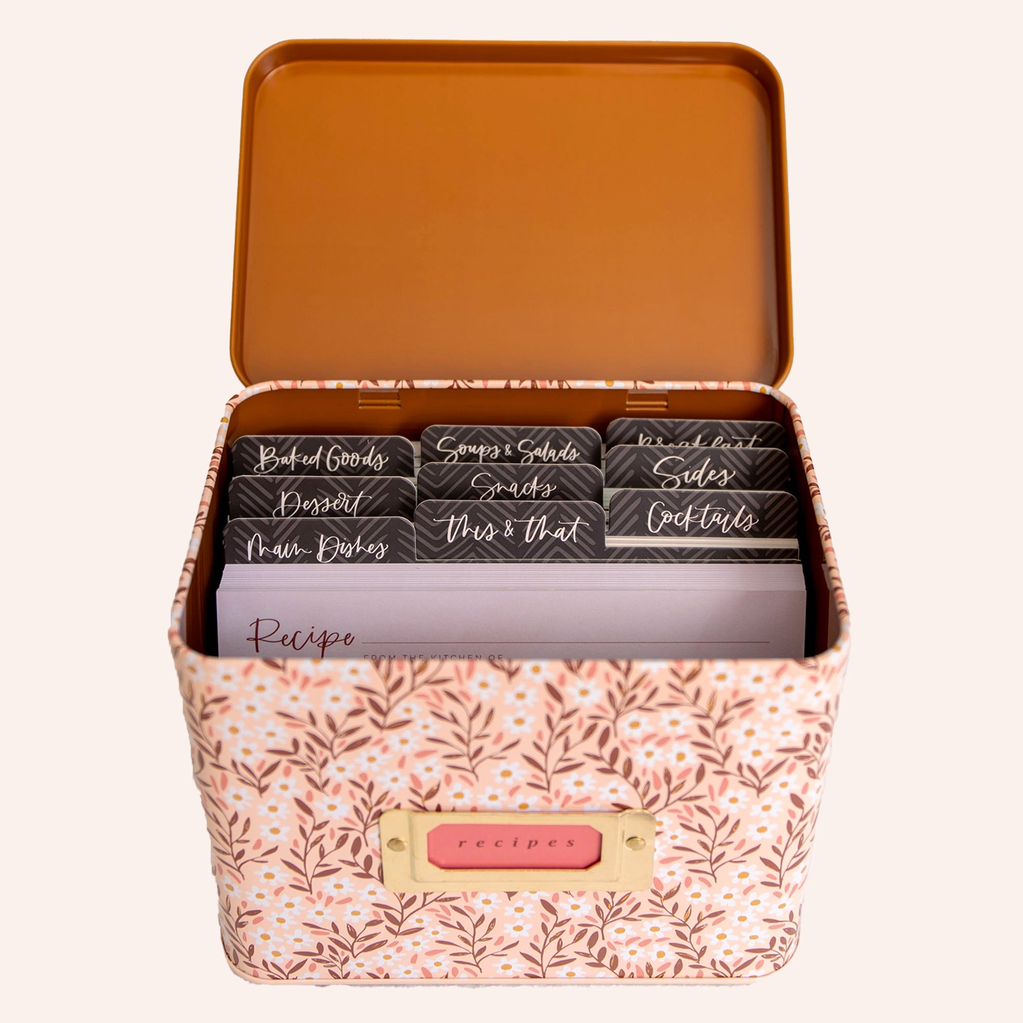 A metal recipe box with a pink daisy pattern with recipe cards and dividers.