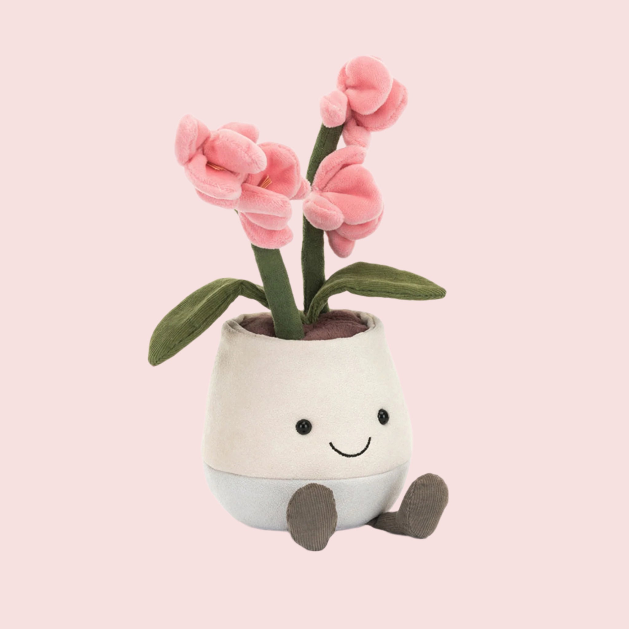 A stuffed toy in the shape of a potted pink orchid with a smiling face. 