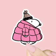 A Snoopy sticker that is wearing a pink puffer jacket. 