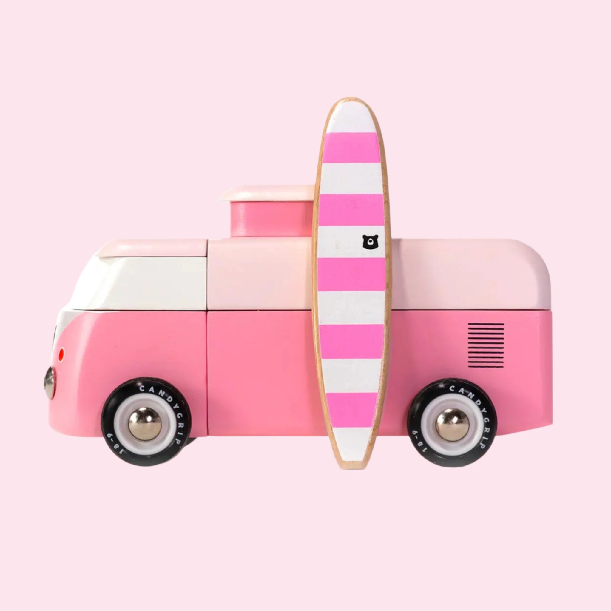 A pink VW wooden toy bus with a magnetic surfboard accessory. 