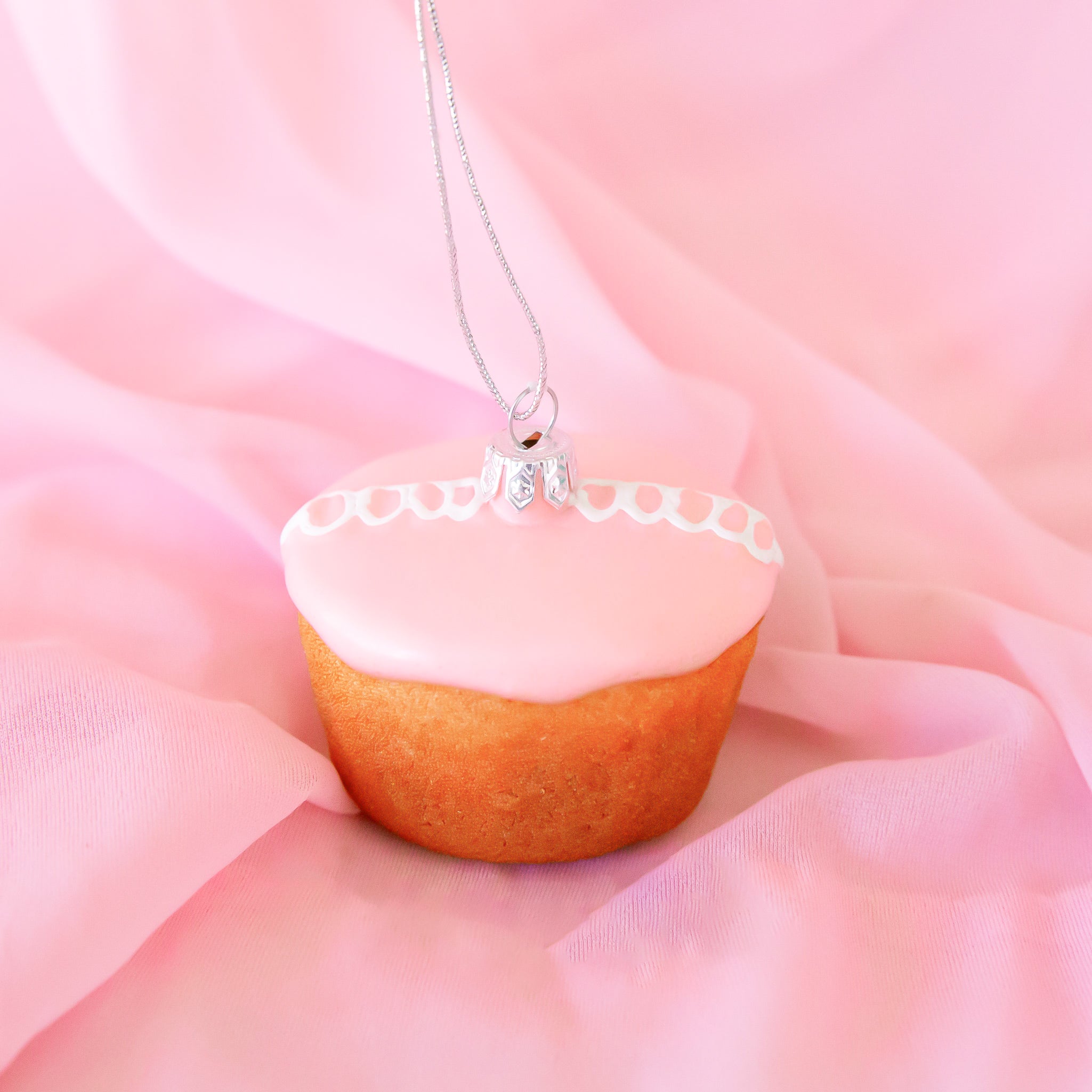 A pink cupcake shaped glass ornament. 