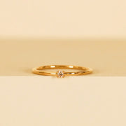 A gold dainty ring with a small champagne CZ stone in the center. 