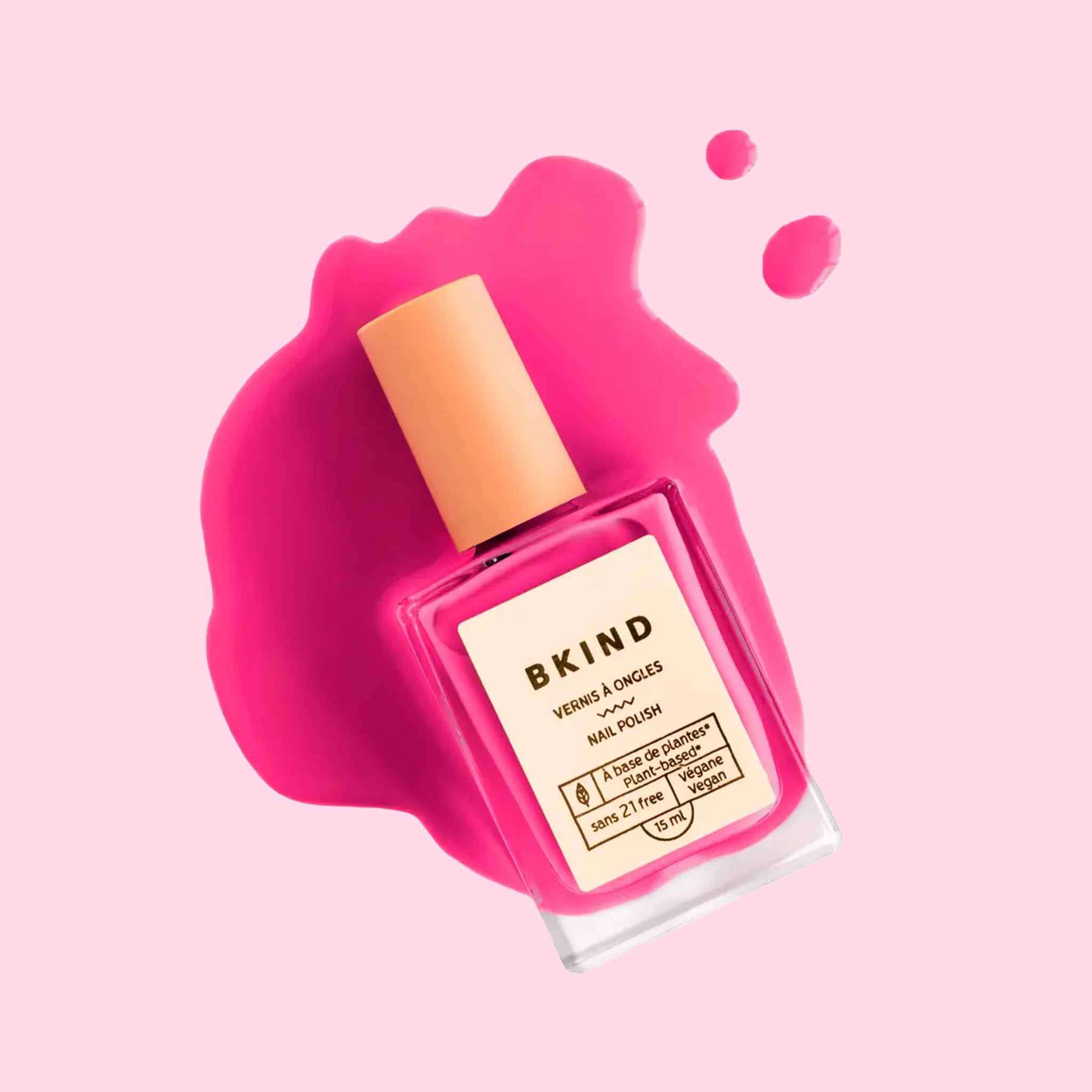 A bright fuchsia shade of nail polish in a rectangle bottle. 