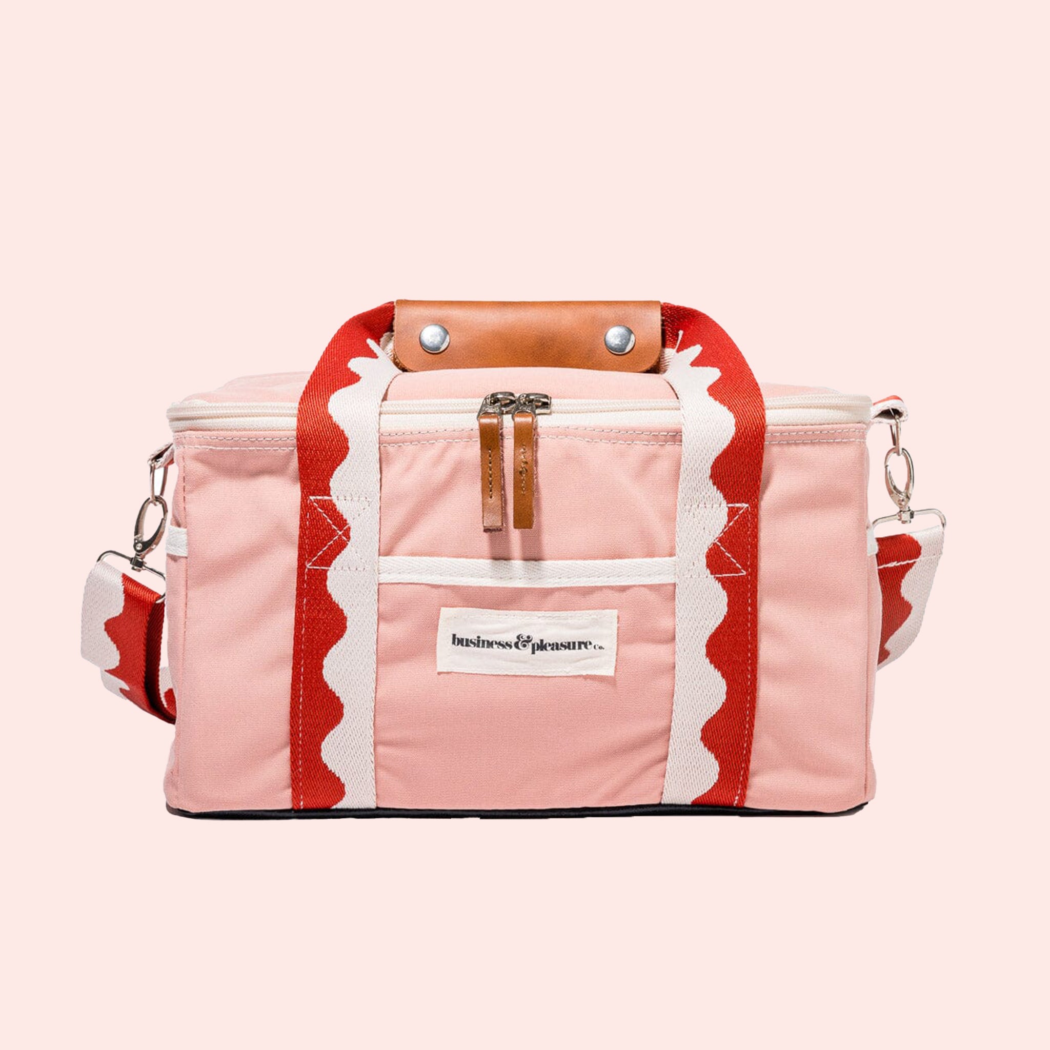 A pink and red premium cooler bag with leather handle straps. 