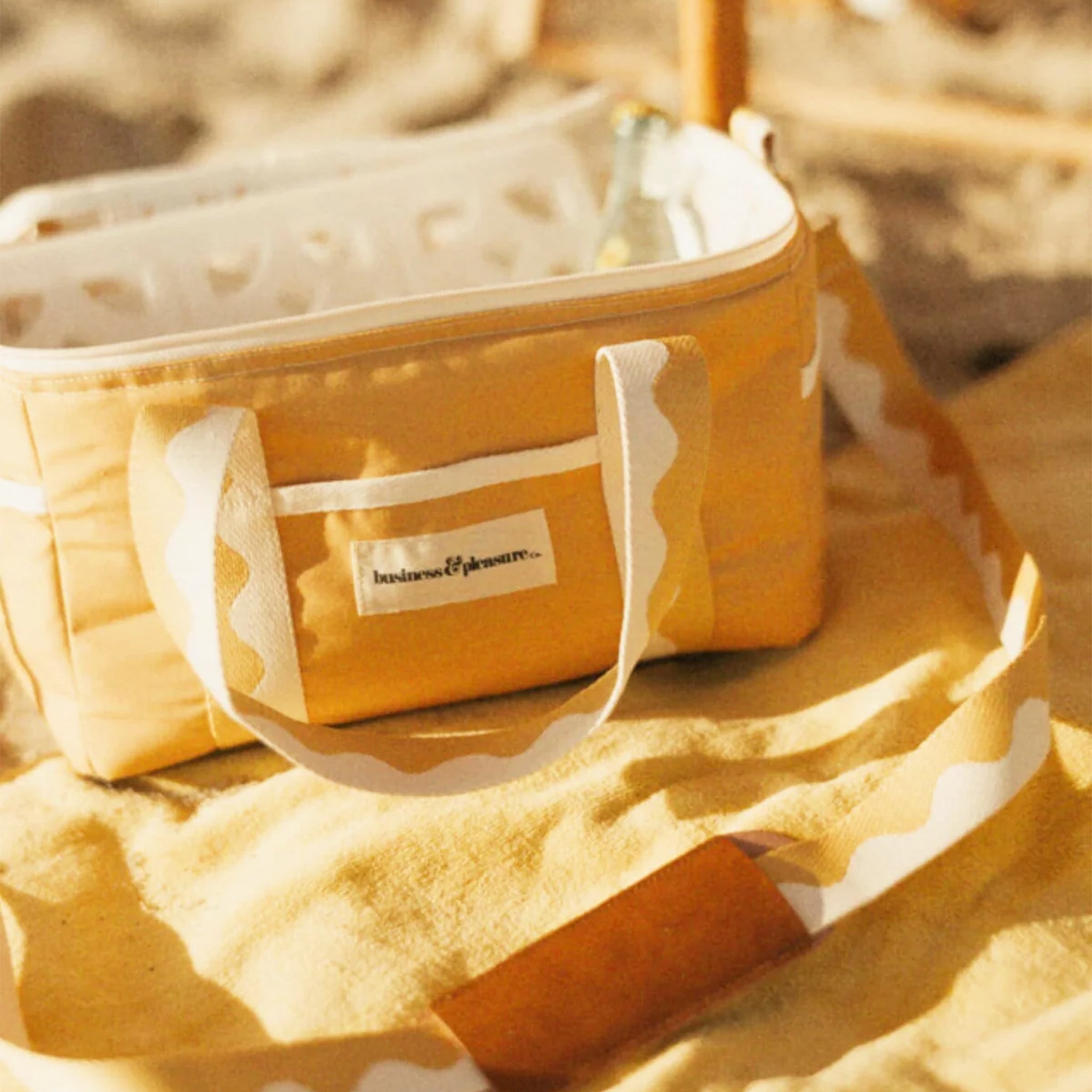 A yellow cooler bag with wavy ivory and yellow handles.